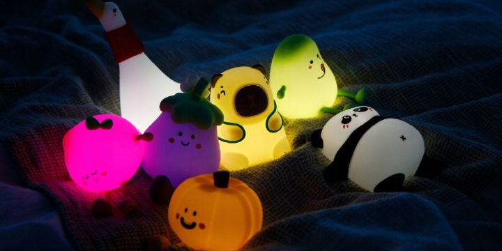 Urocze, świecące lampki nocne w kształcie owoców, warzyw i zwierząt na kocu.