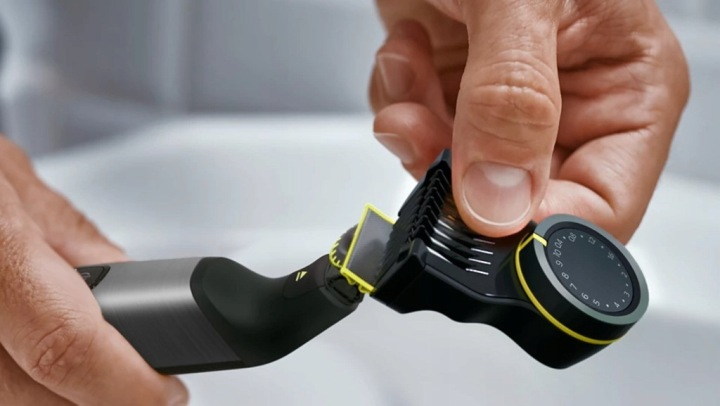 Dłoń reguluje czarny trymer z żółtymi akcentami.