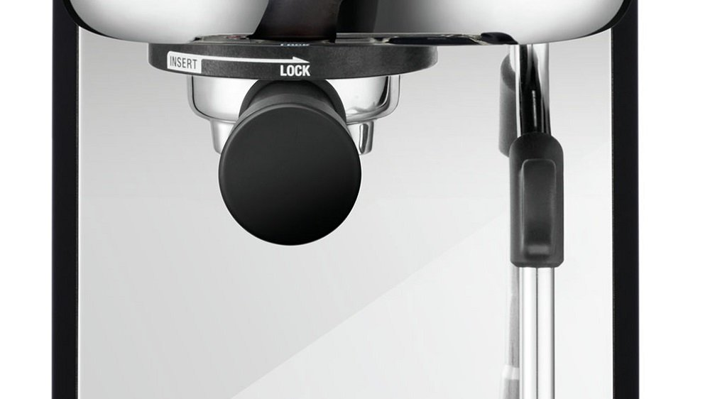 Zbliżenie ekspresu do kawy z czarną rączką i pokrętłem.