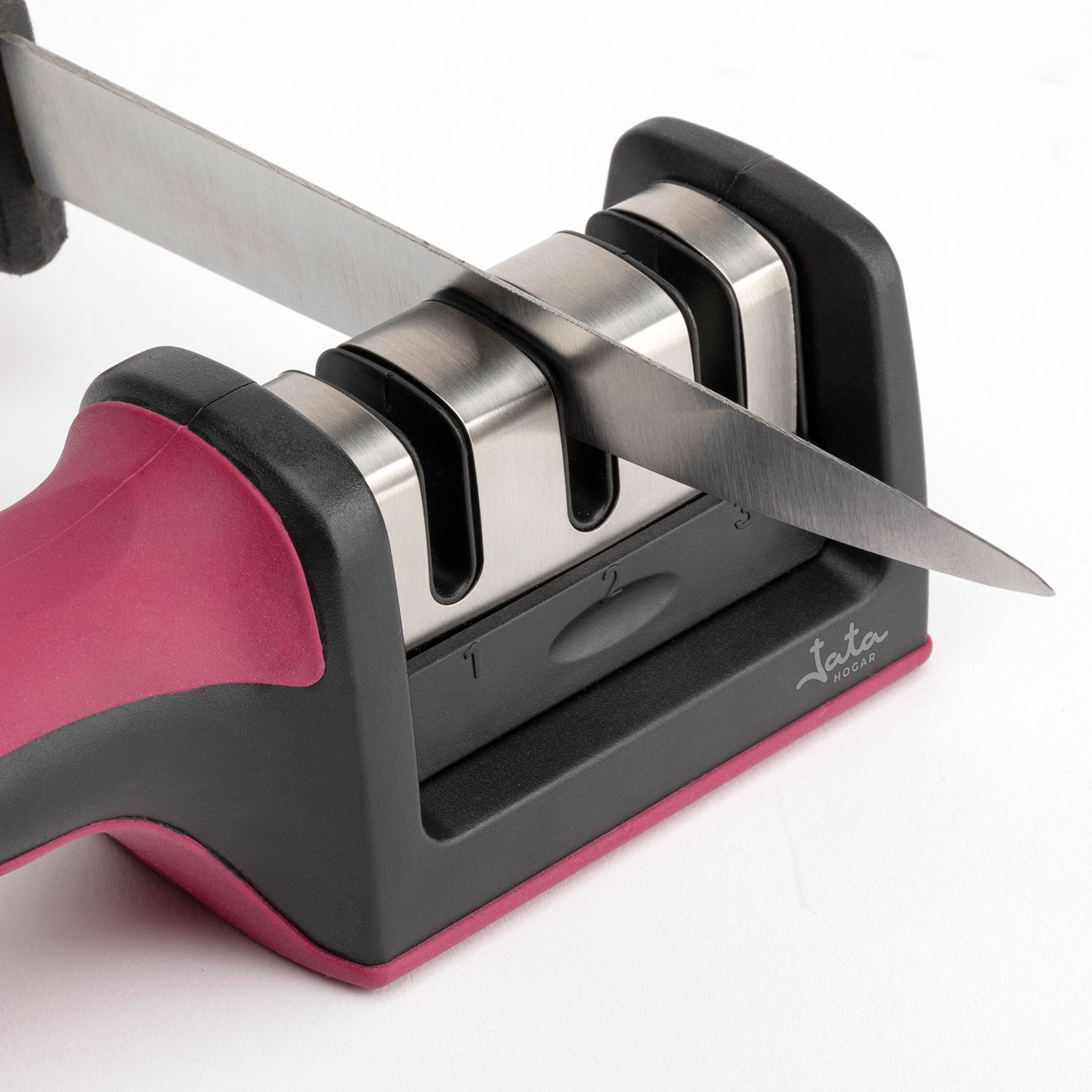 Un afilador de cuchillos con mangos rojos y negros, se está afilando un cuchillo.