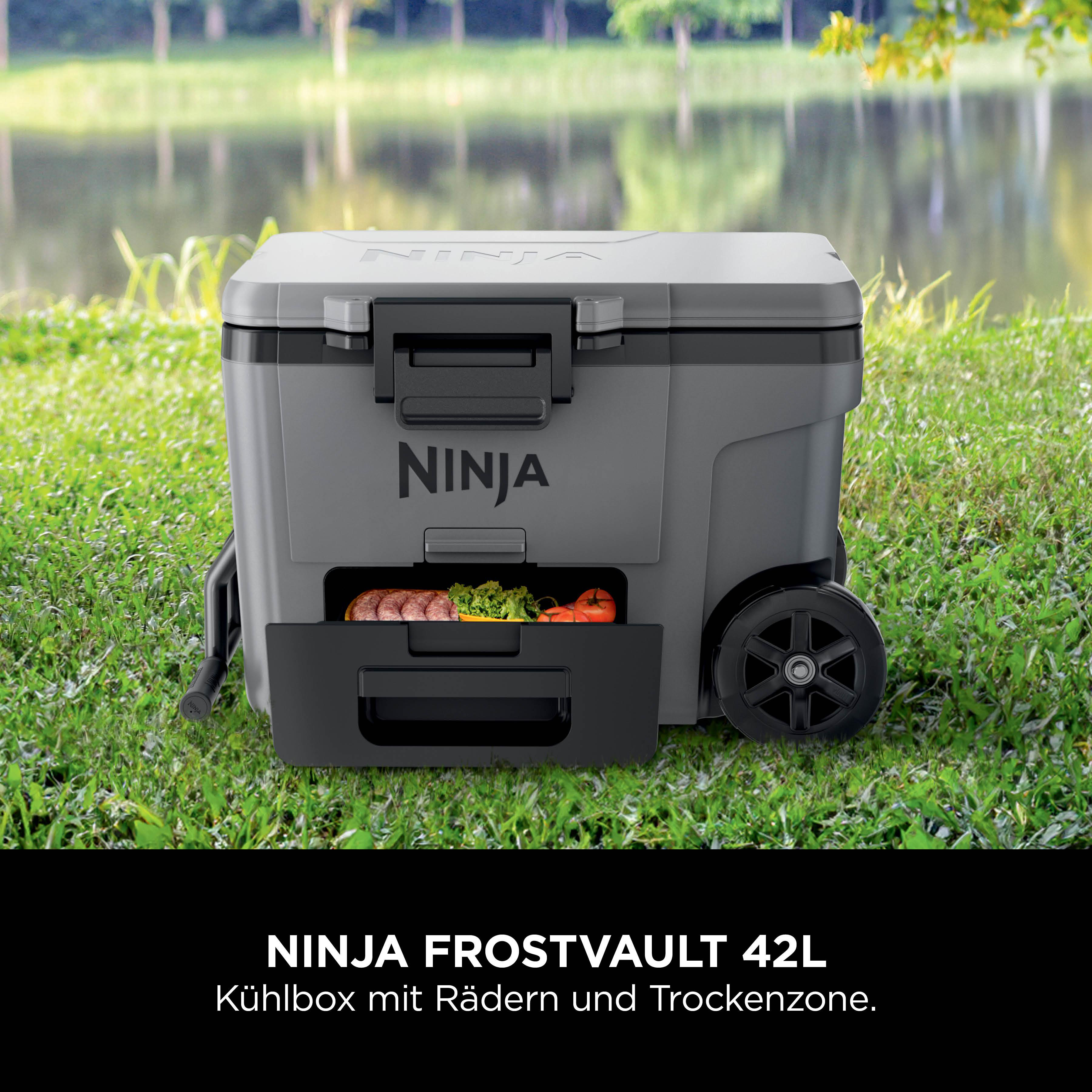 Graue Ninja Kühlbox mit Rädern und geöffnetem Fach mit Lebensmitteln.