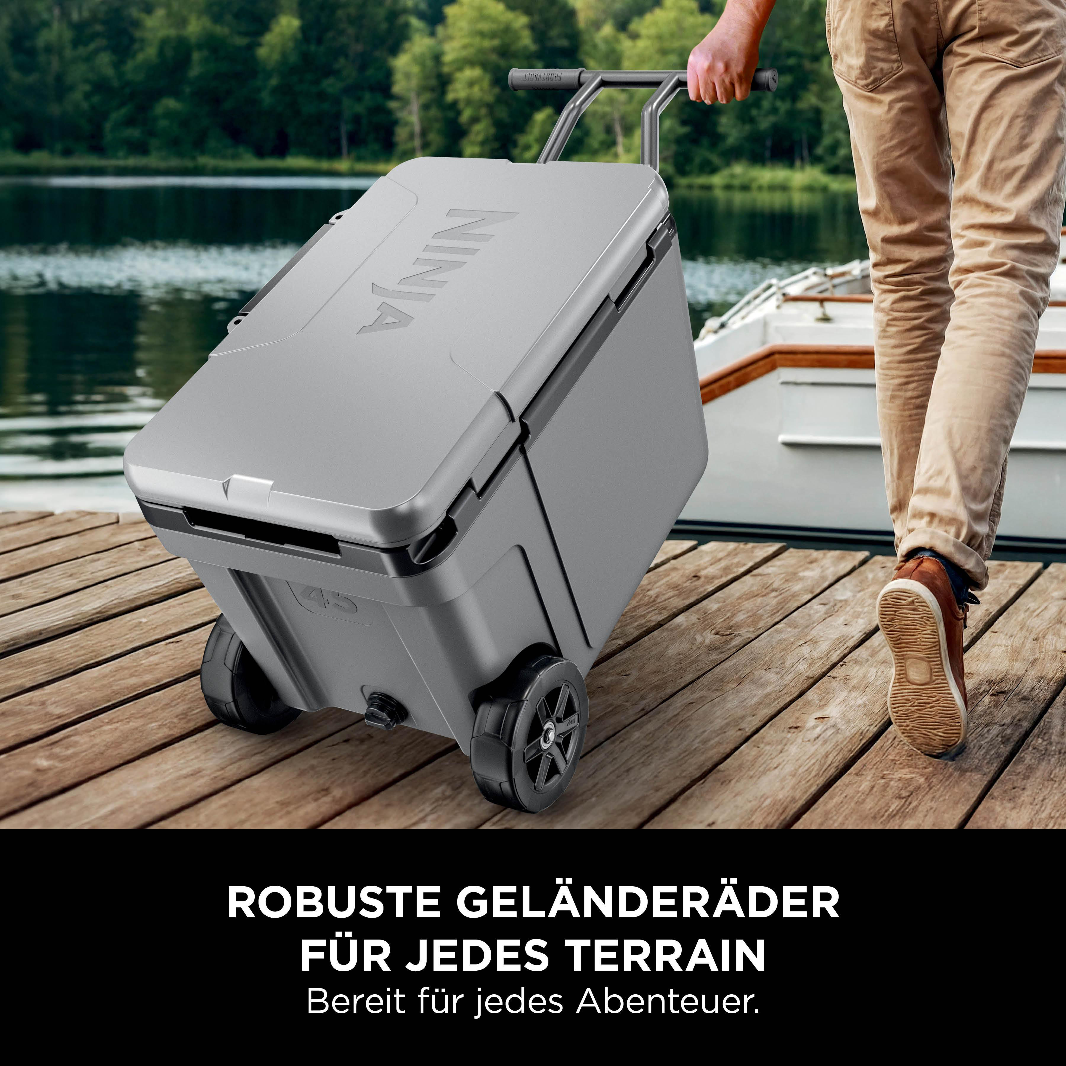 Grauer Rollkühler mit Ninja-Logo auf Holzsteg am Wasser.