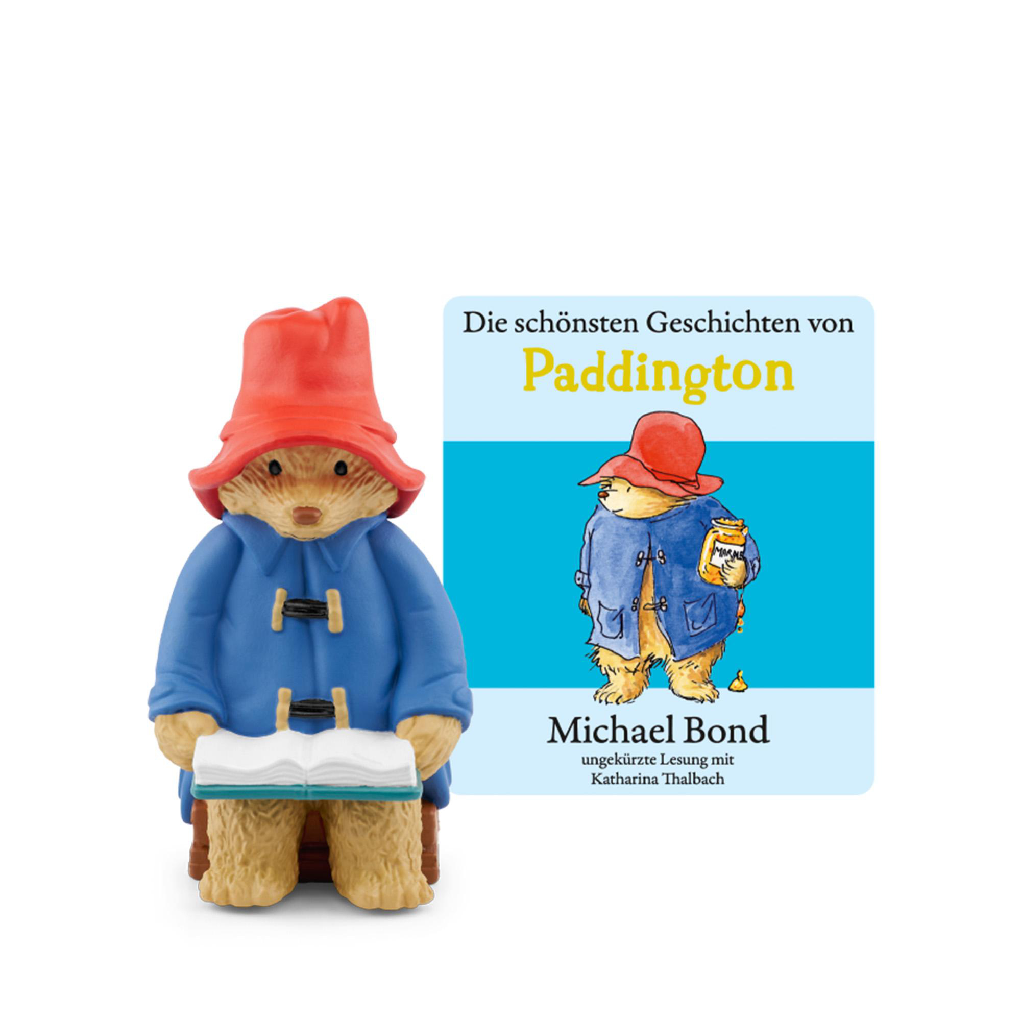 Paddington Bär Figur liest ein Buch, daneben Buchcover mit Paddington.