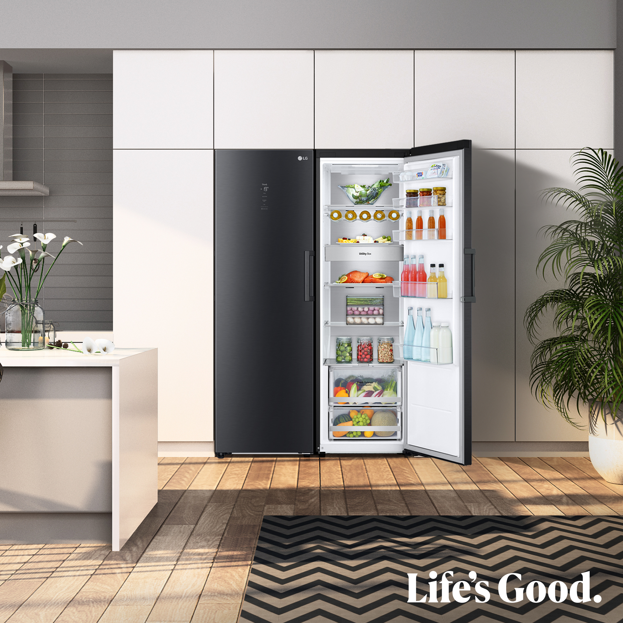 Un refrigerador LG negro con la puerta abierta, lleno de comida. Una planta a su lado.