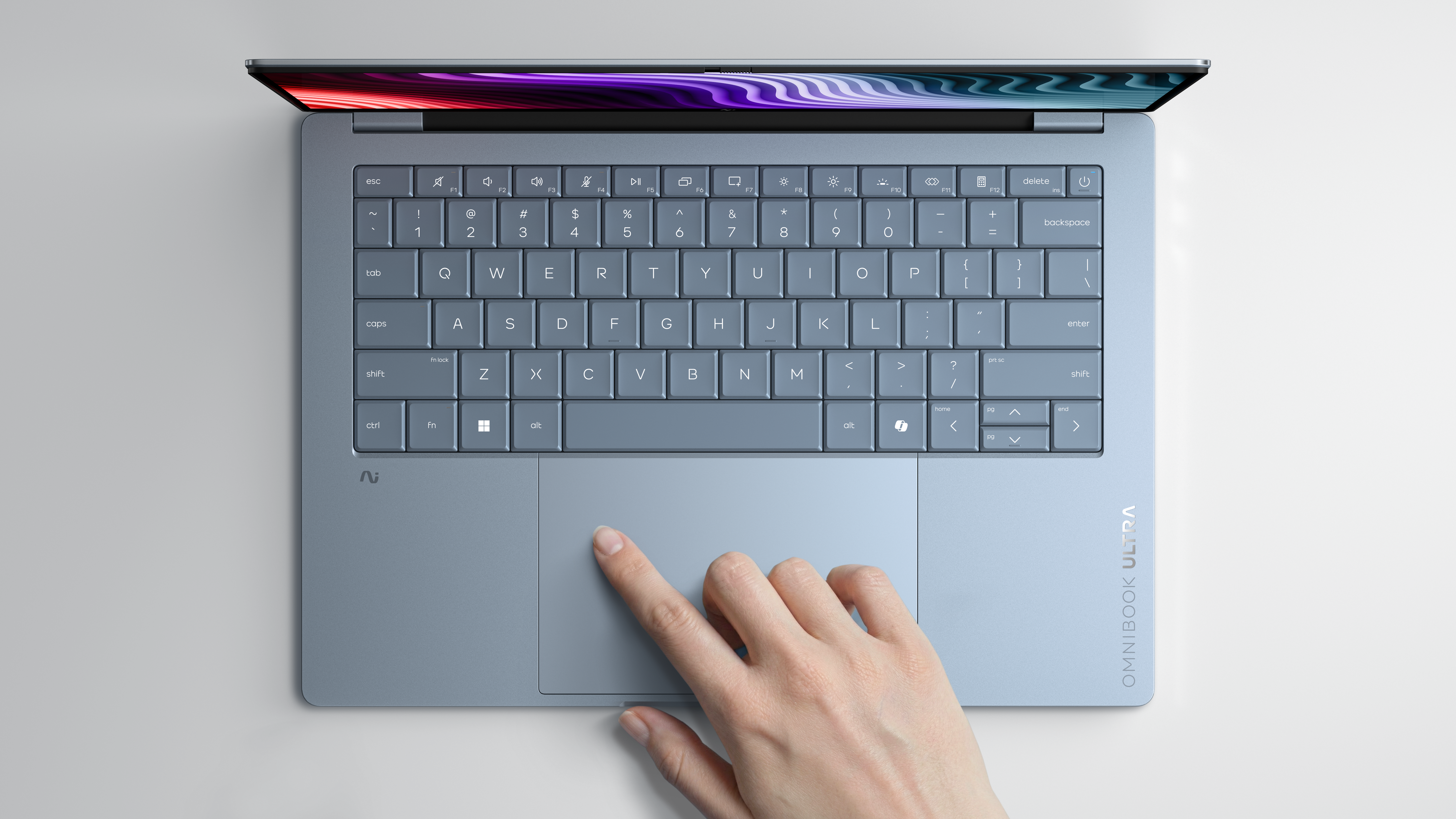 Eine Hand berührt das Touchpad eines offenen Laptops mit blauer Tastatur.