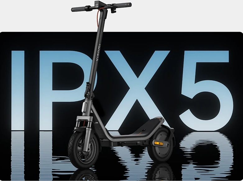 Ciemny skuter elektryczny Xiaomi na odblaskowej powierzchni przed dużym napisem IPX5.
