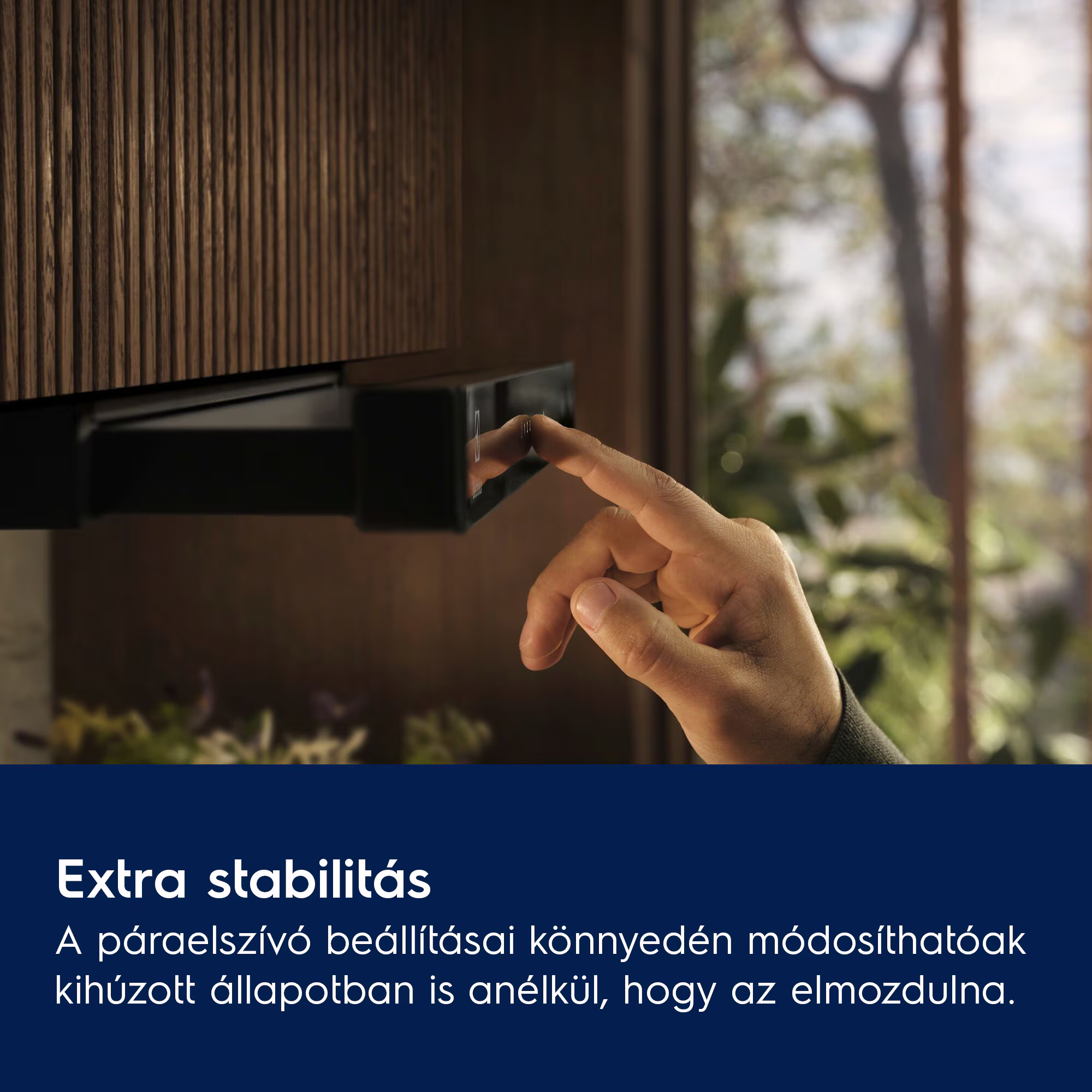 Egy kéz fekete vezérlőpanelt érint fa fal előtt. Kint zöld van.