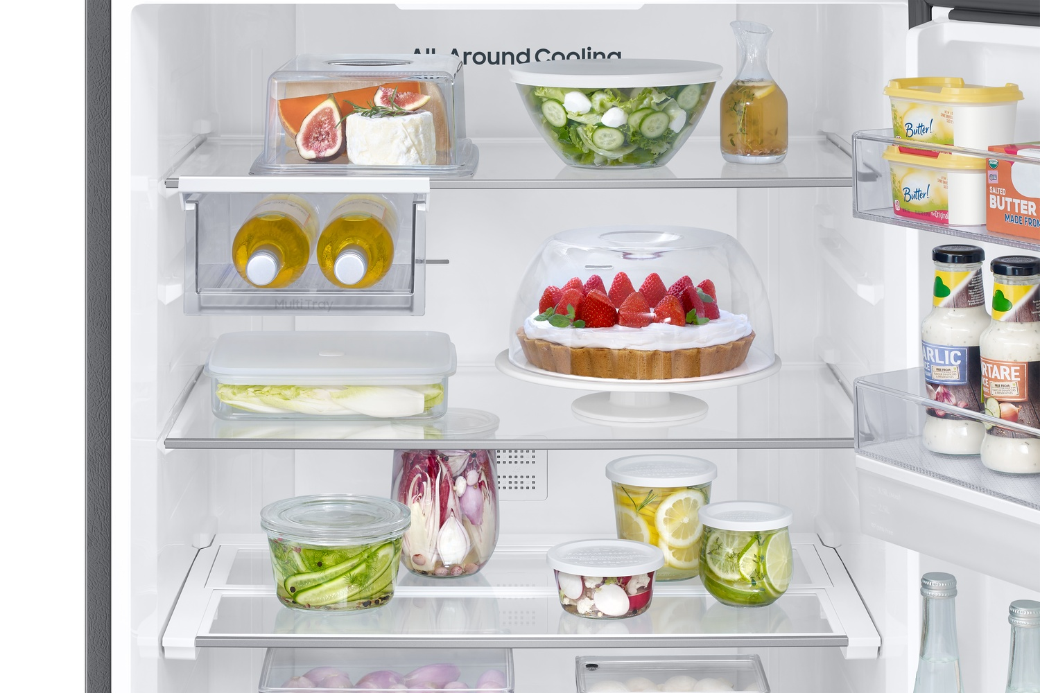 Estantes de refrigerador con frutas, pastel, verduras y mantequilla.