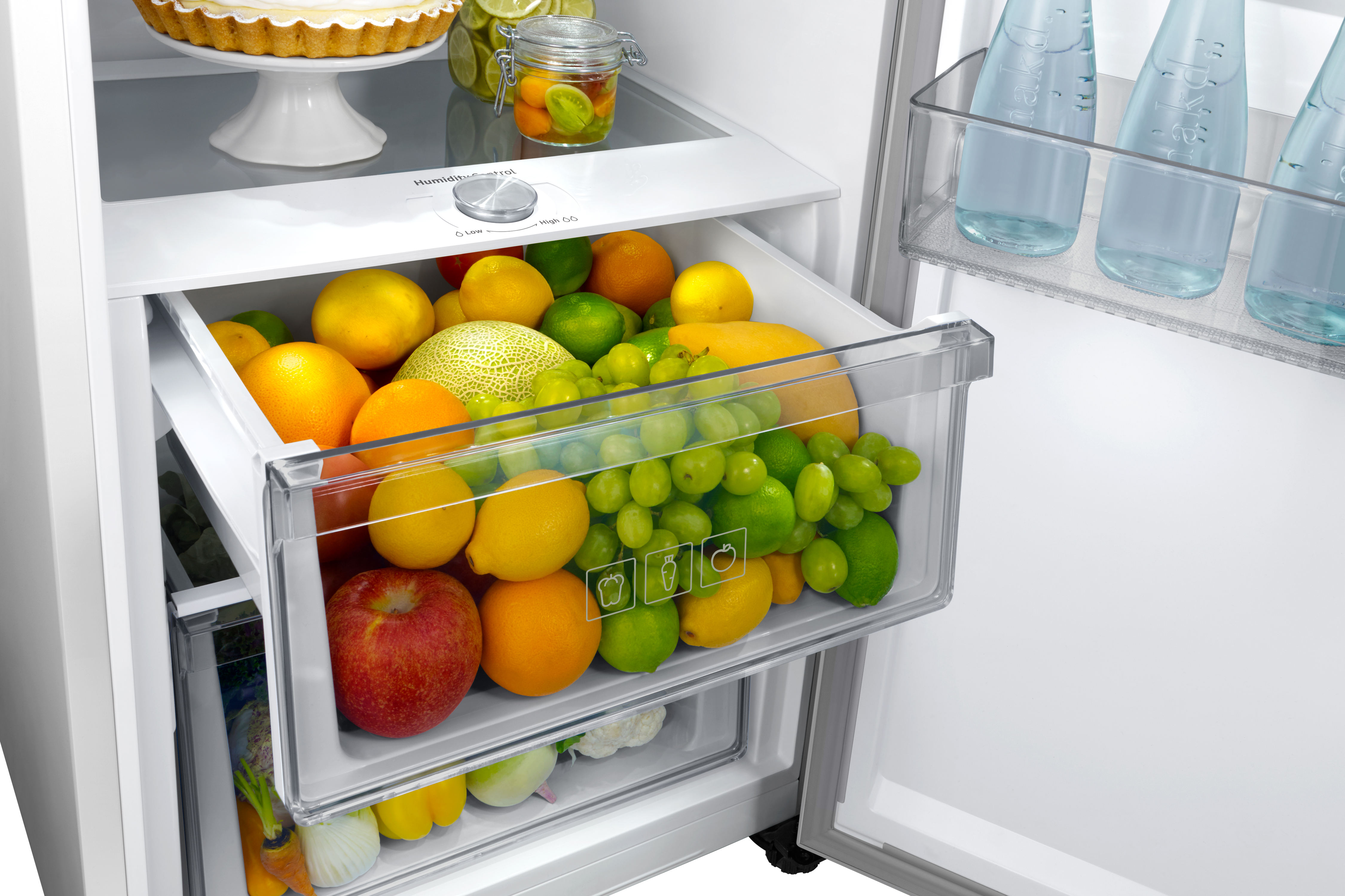 Nevera con frutas: manzanas, naranjas, limones, uvas, melón, limas.
