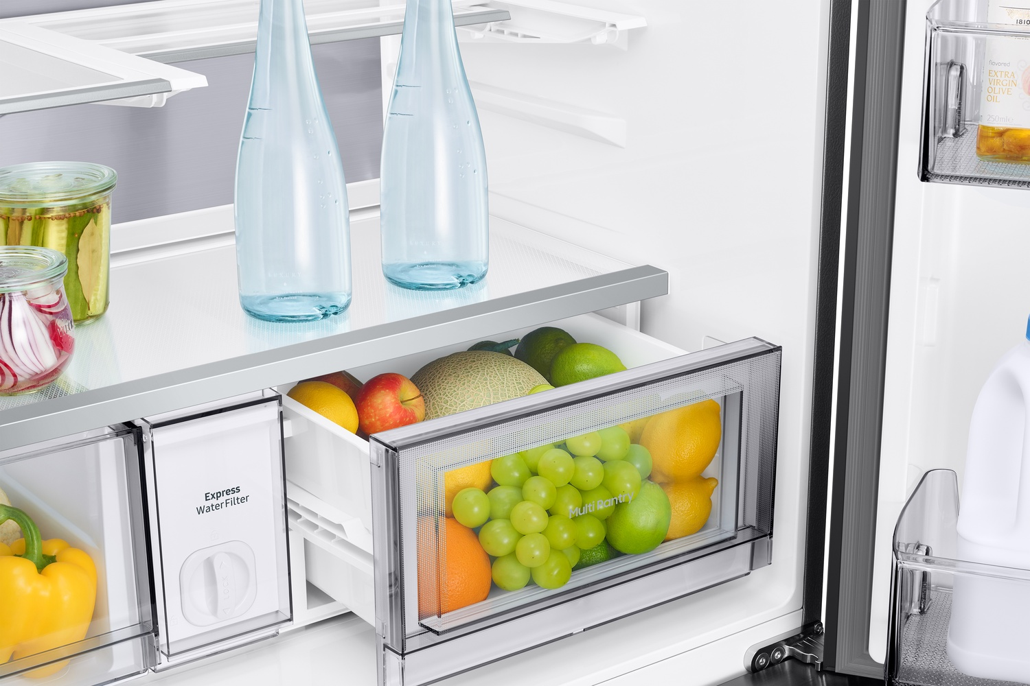 Interior del refrigerador con frutas, verduras, botellas de agua y filtro de agua.