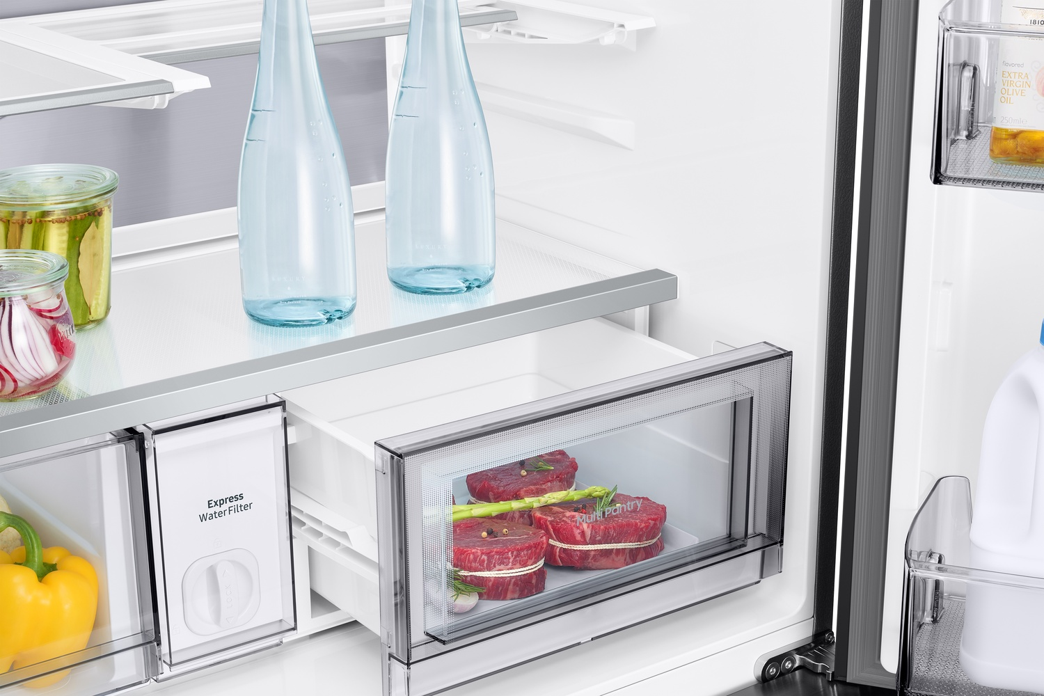 Un cajón de refrigerador con carne, botellas y frascos. Un pimiento amarillo abajo.
