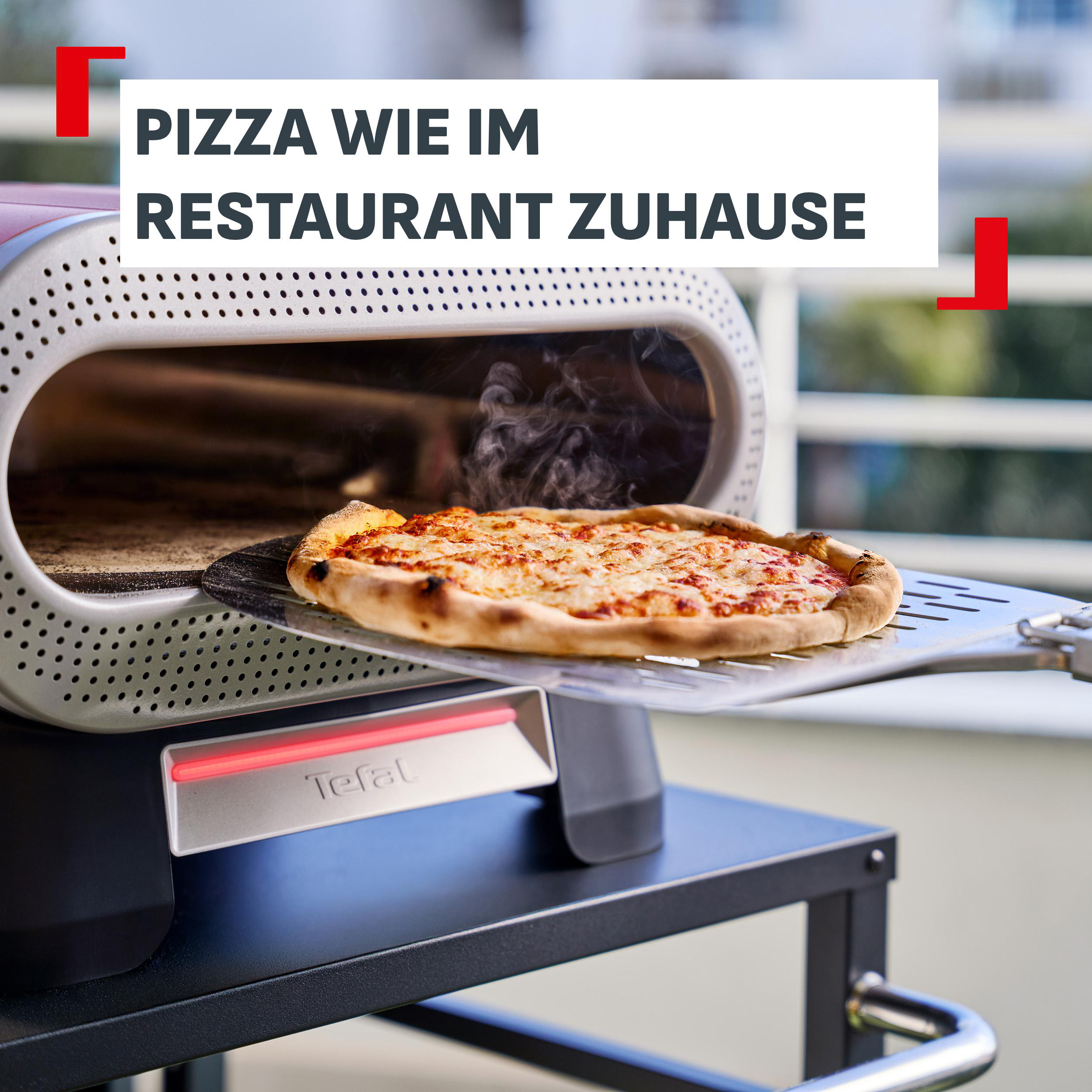 Eine dampfende Pizza wird aus einem Pizzaofen auf einer Pizzaschaufel entnommen.
