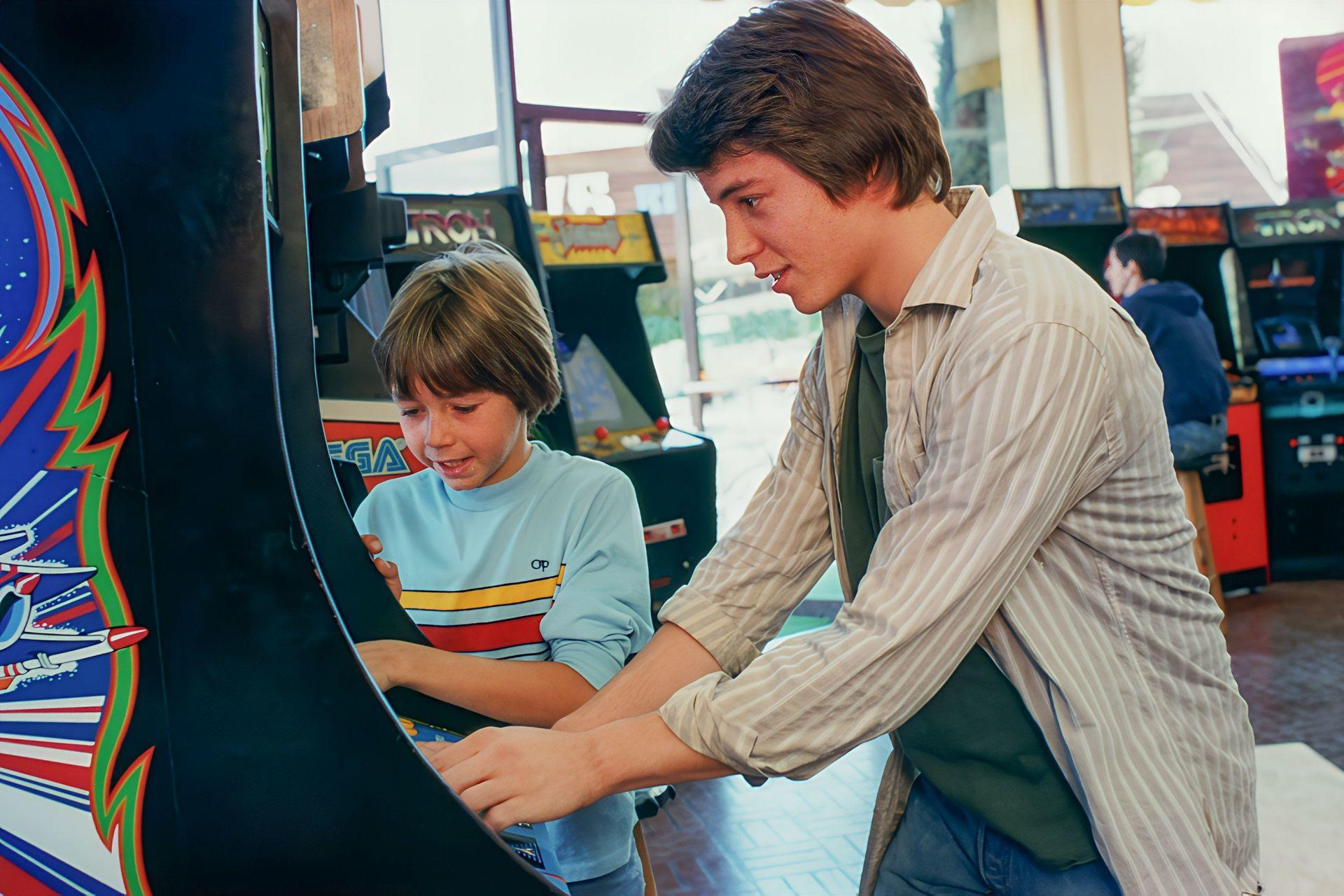 Zwei Jungen spielen ein Arcade-Spiel in einem Spielesaal.