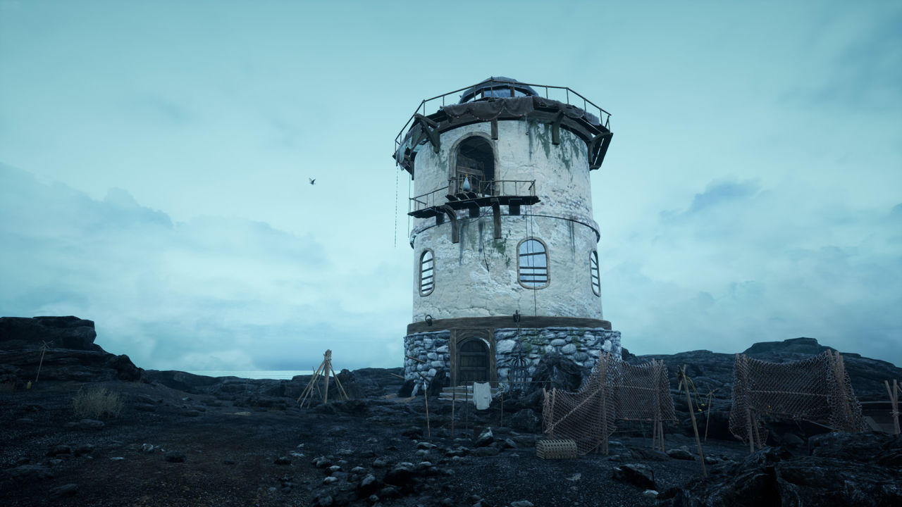 Ein runder, verwitterter Turm mit Steinsockel und Holzdetails steht auf felsigem Boden.