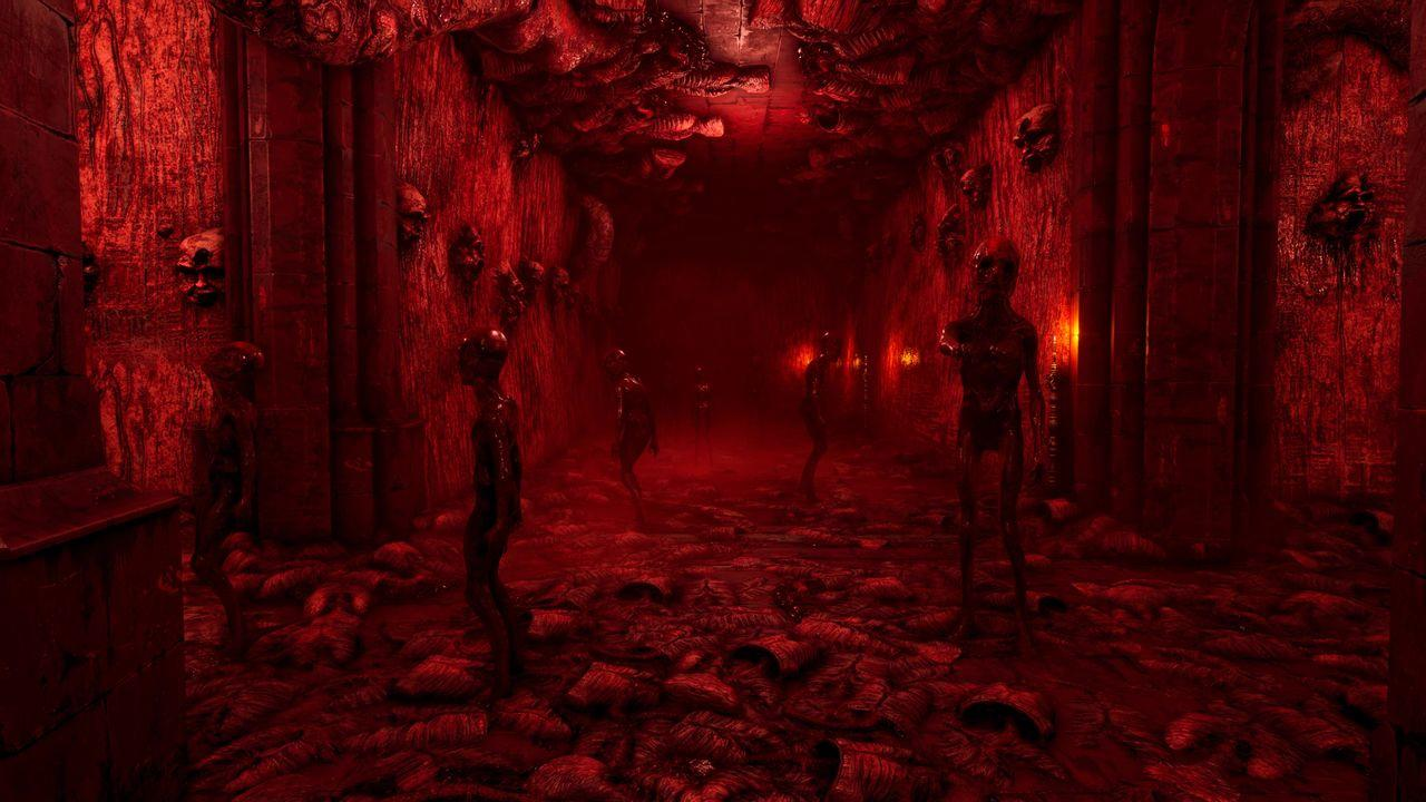 Schmale rote Höhle mit grotesken Figuren und Schädeln an den Wänden.