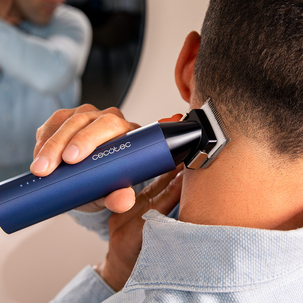 Hombre recorta cuello con cortapelos azul, espejo al fondo.