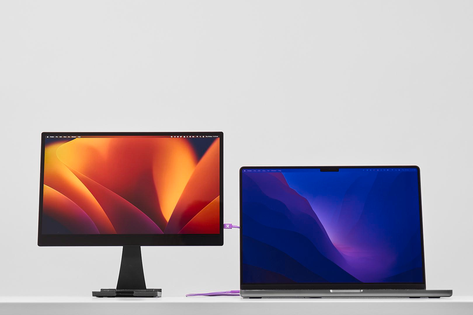 Ein externer Monitor und ein Laptop sind nebeneinander aufgestellt.