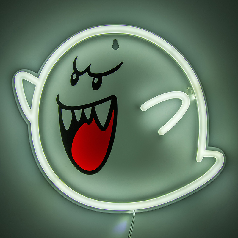 Eine weiße Neonlampe in Form eines grinsenden Geistes mit roten Mund.