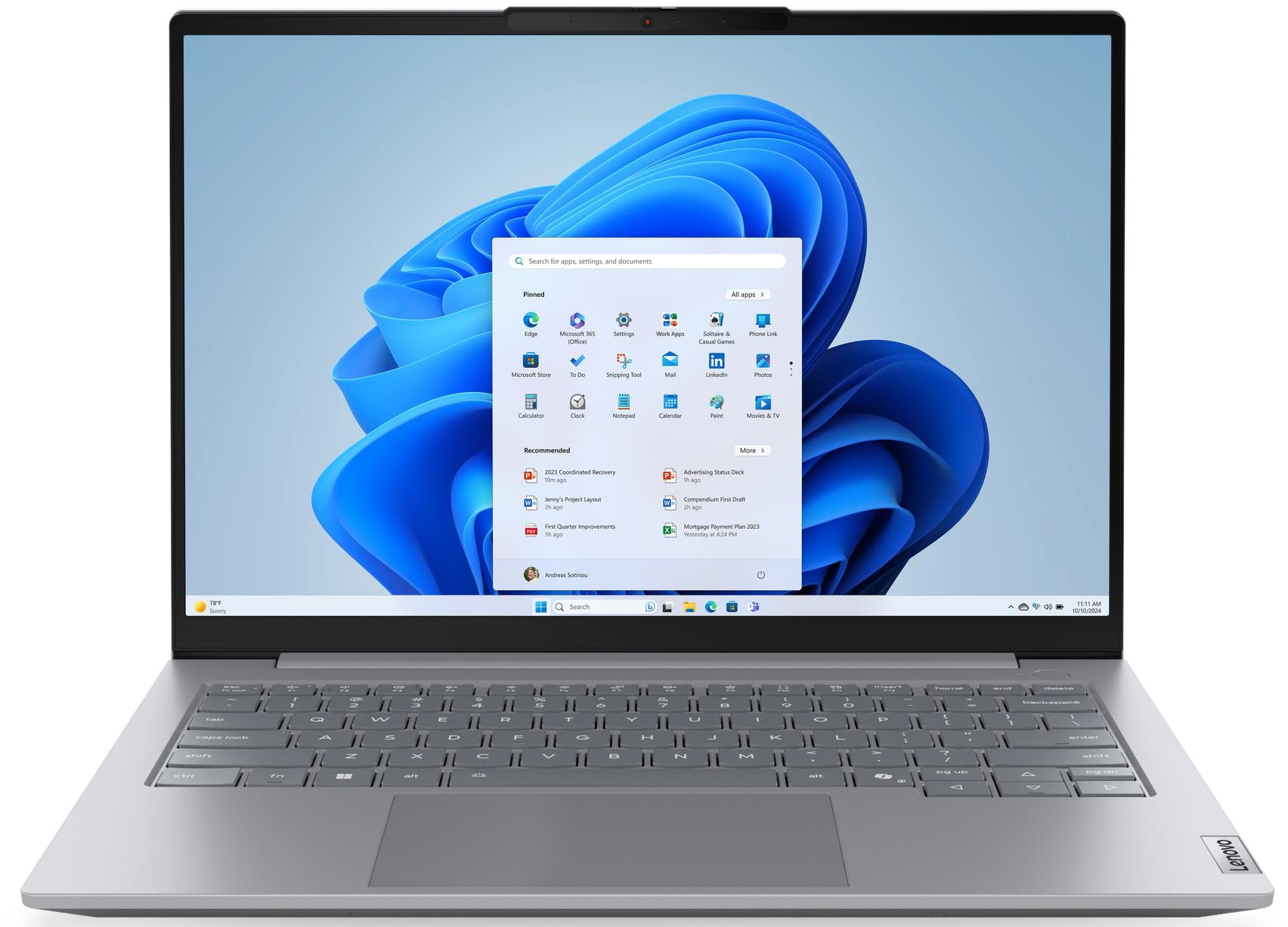 Egy nyitott laptop Windows 11 "start" menüvel és kék háttérképpel.