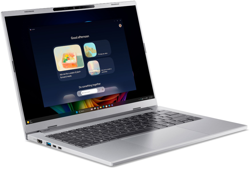 Ezüst laptop sötét képernyővel, zöld és színes elemekkel.