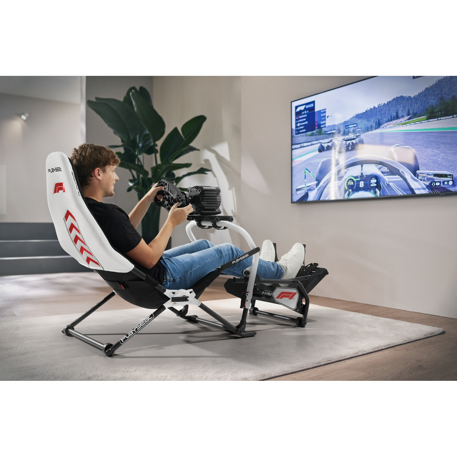 Homme joue à un jeu de course dans un fauteuil simulateur avec volant et pédales, graphismes F1.