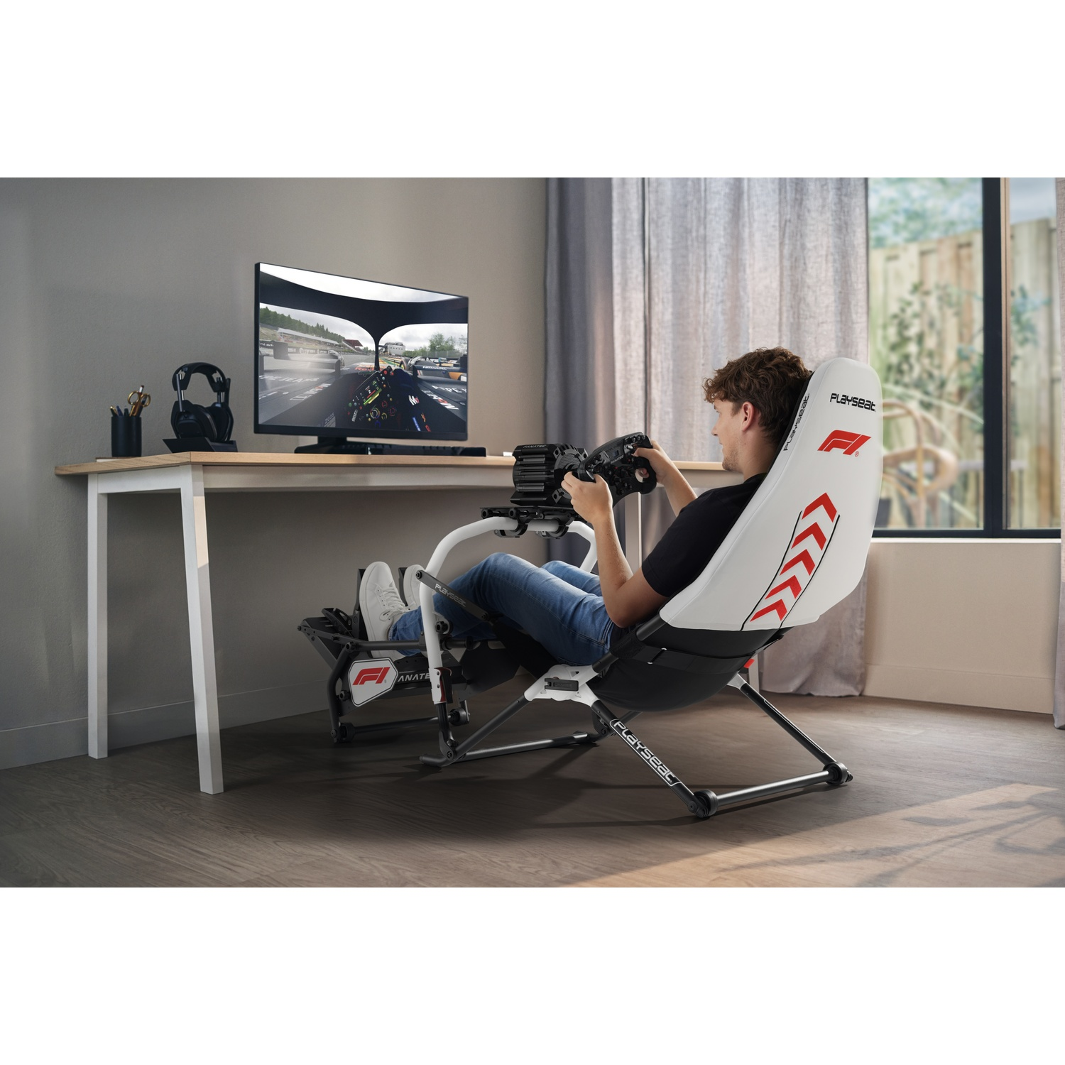 Un homme est assis dans un fauteuil de simulateur de course, jouant sur un écran.