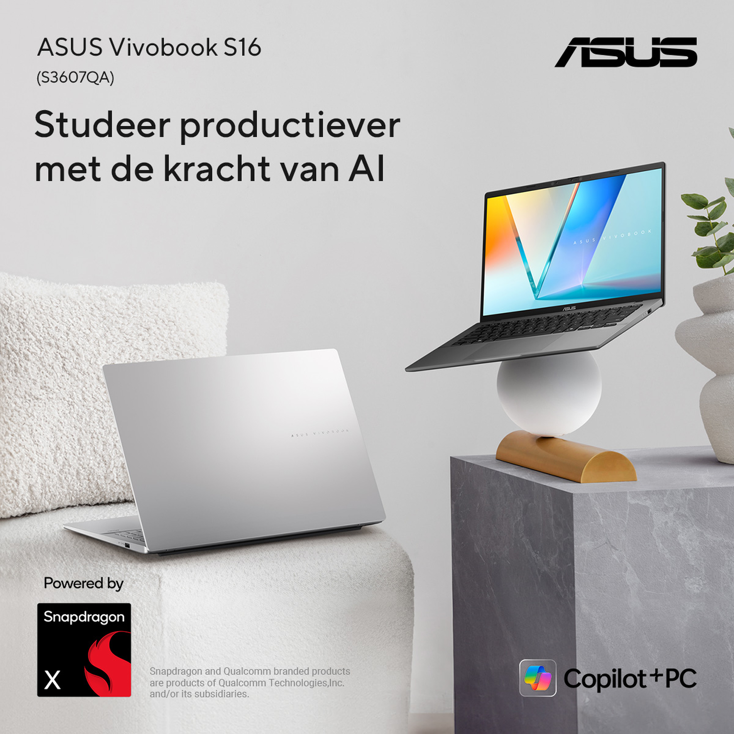 Two ASUS Vivobook laptops on a table, one open, one closed.