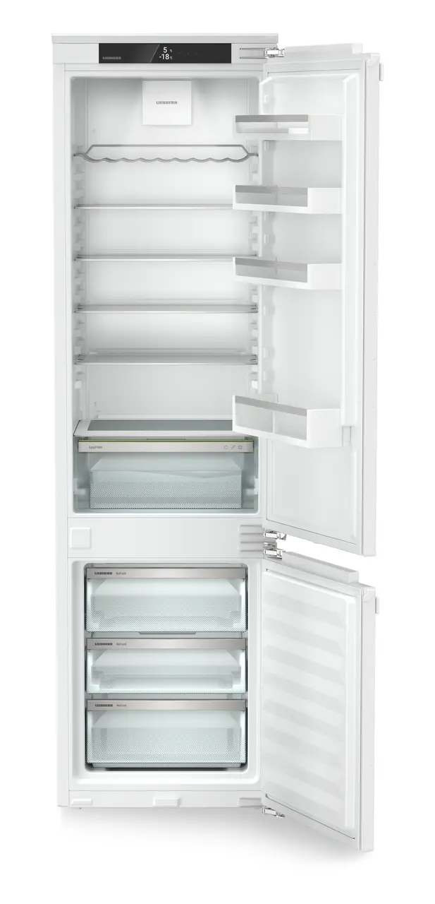 Egy fehér hűtőszekrény nyitott ajtóval, üvegpolcokkal és fagyasztófiókokkal.