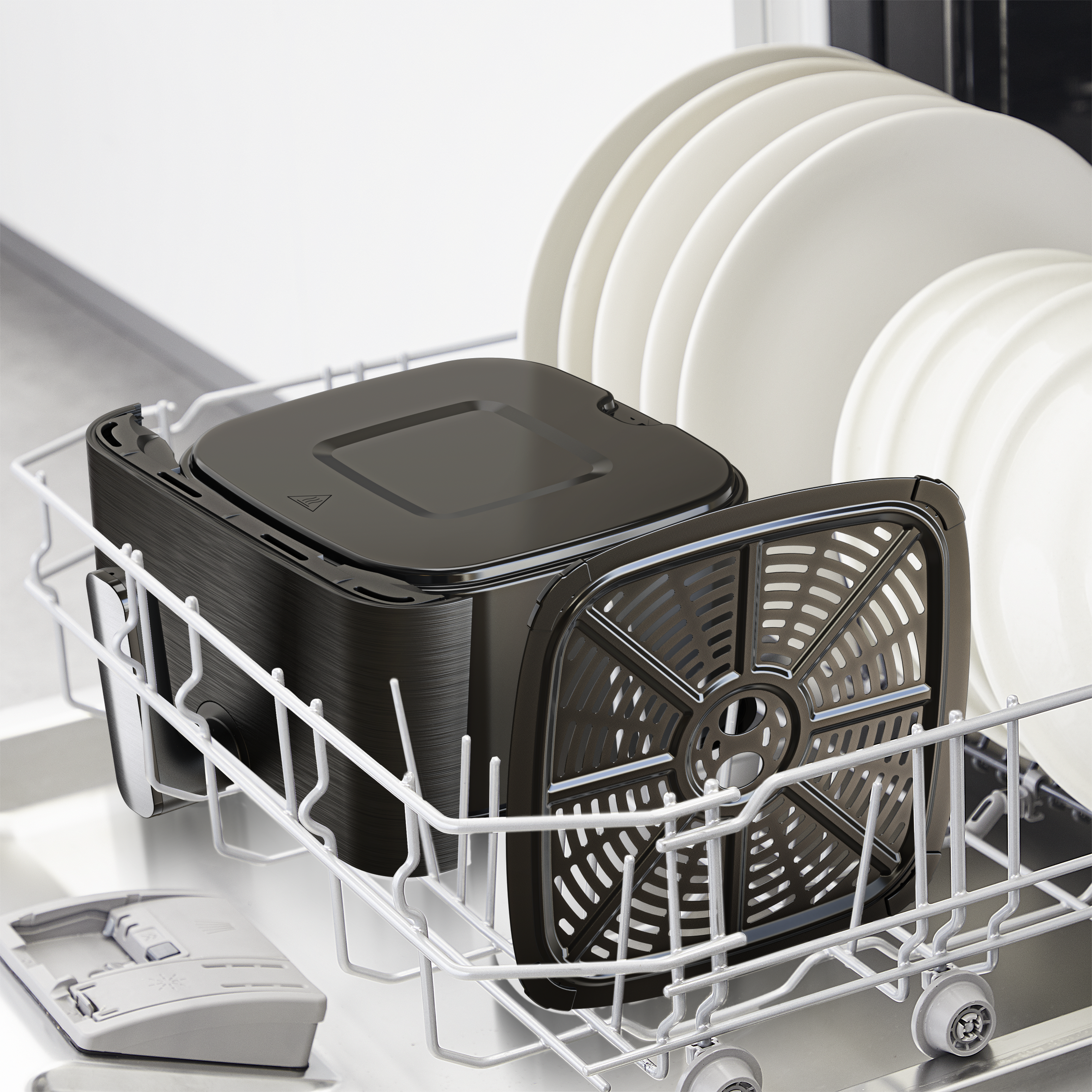 Egy fekete airfryer kosár és tányérok egy mosogatógépben.