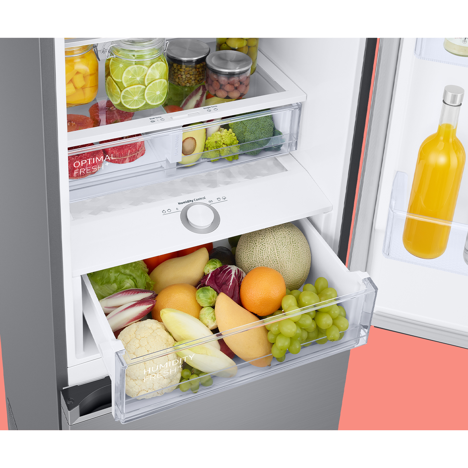 Dentro de un refrigerador, los cajones contienen productos frescos como frutas y verduras. Se ve una botella de jugo.