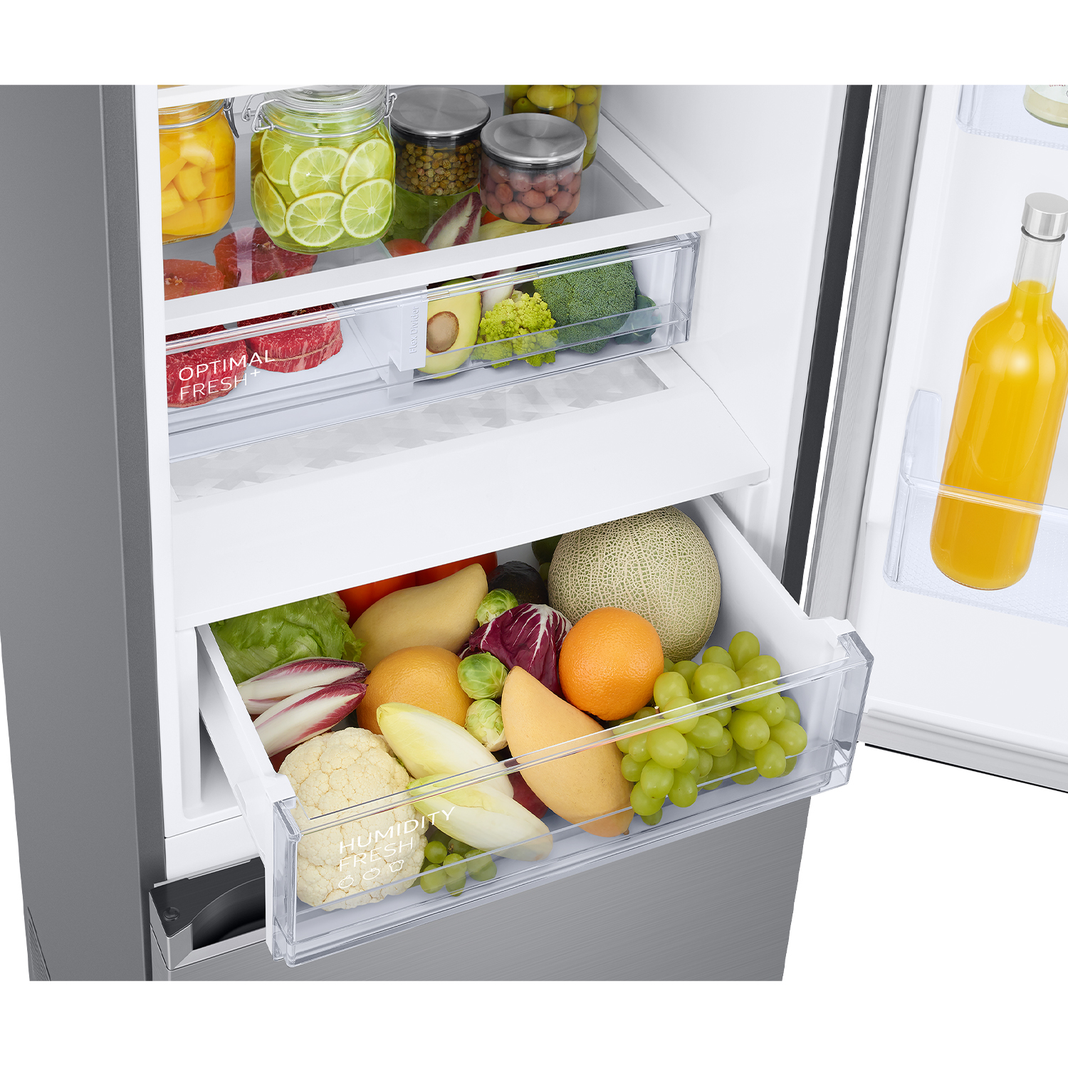 Nevera con dos cajones llenos de frutas y verduras, y una botella de jugo.