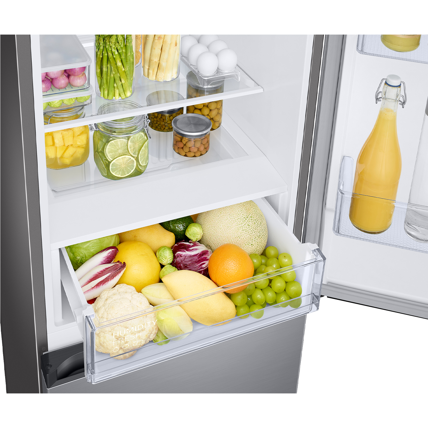 Refrigerador abierto con frutas, verduras, huevos y una botella de jugo.
