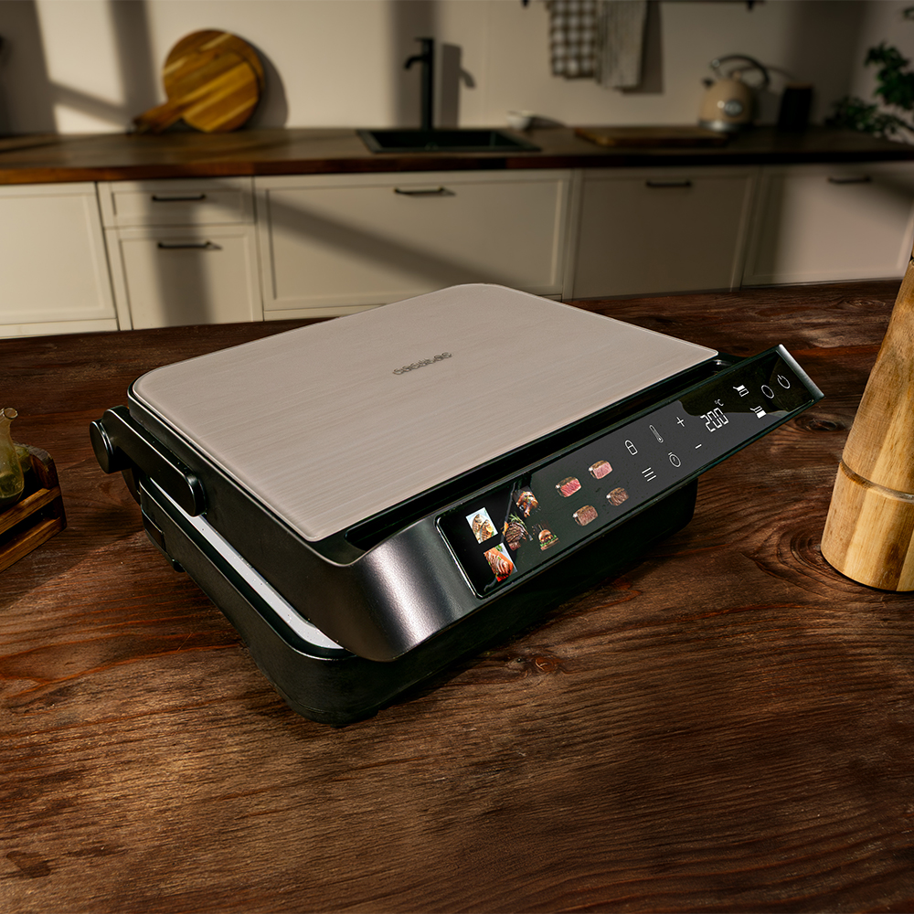 Una parrilla eléctrica moderna con pantalla digital que muestra iconos de comida y 200 grados Celsius.