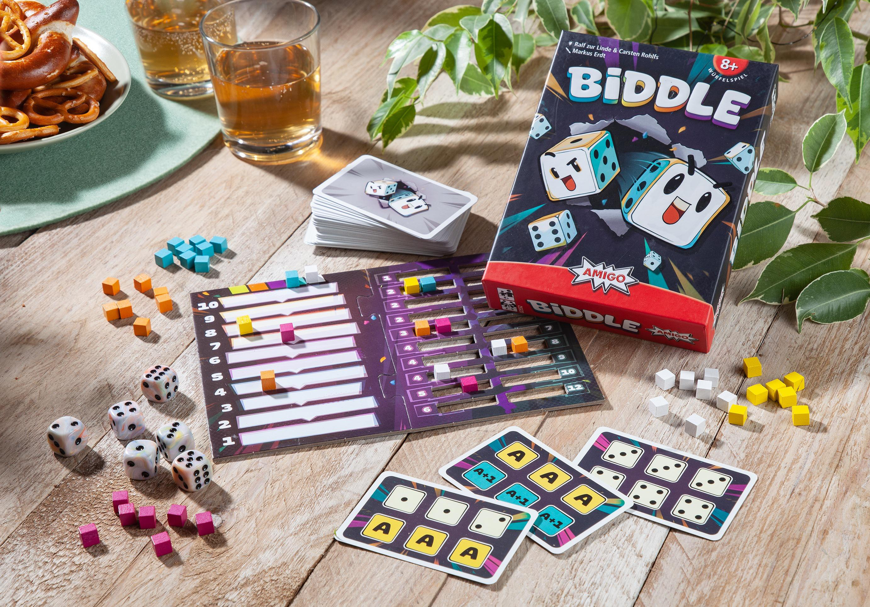 Brettspiel mit Würfeln, Karten und Holzsteinen auf Holztisch.
