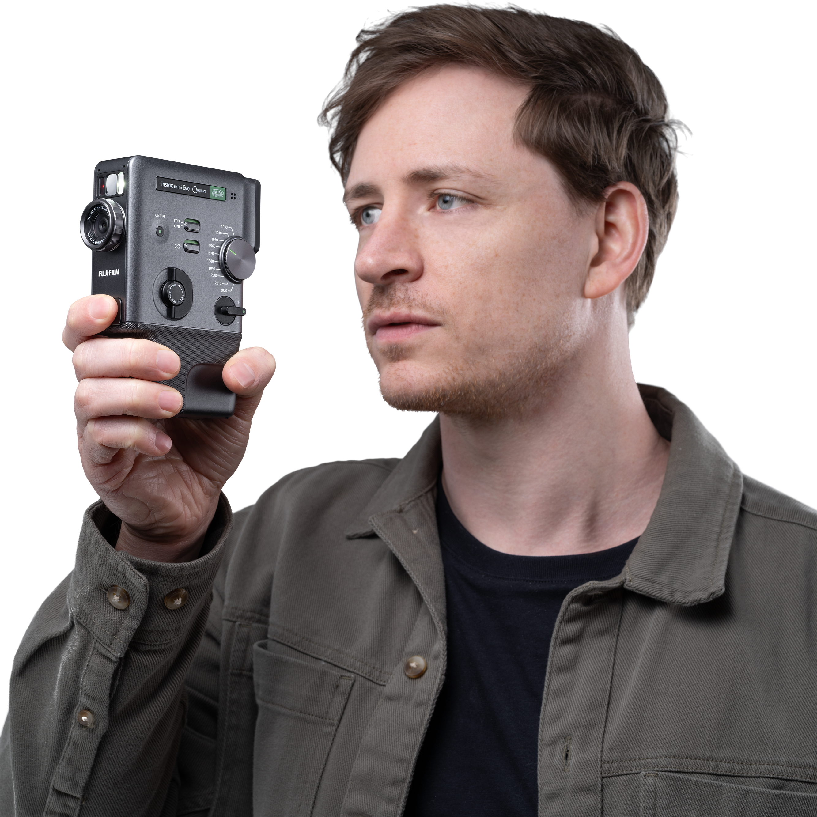 Ein Mann mit braunen Haaren hält eine graue Fujifilm Instax Mini Evo Kamera in der Hand.
