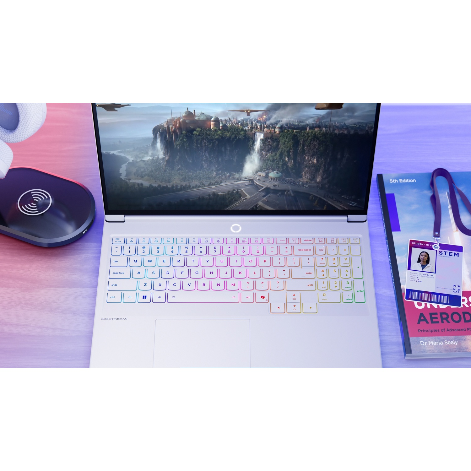 Un laptop che mostra un gioco fantasy, con cuffie e un libro.