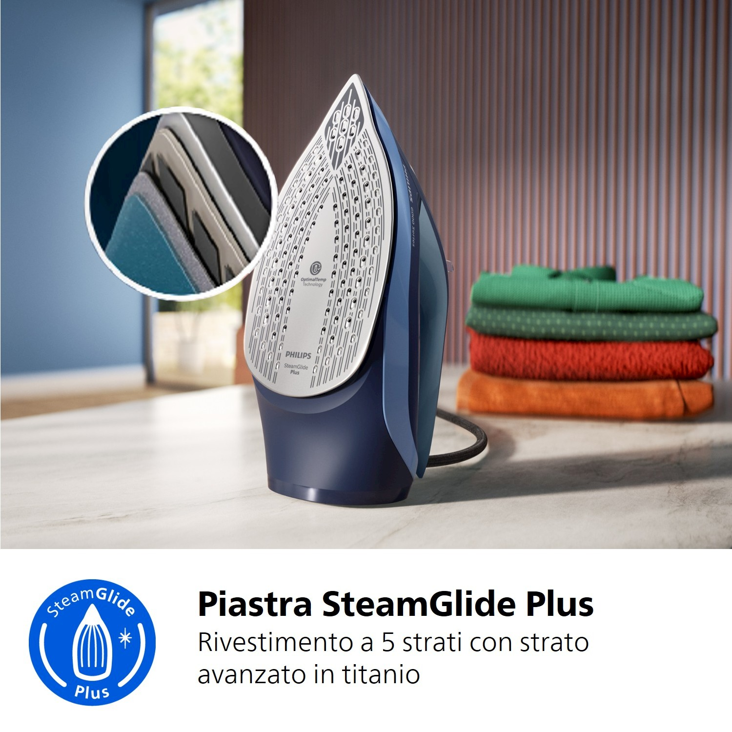 Ferro da stiro blu con rivestimento a 5 strati, accanto a vestiti impilati.