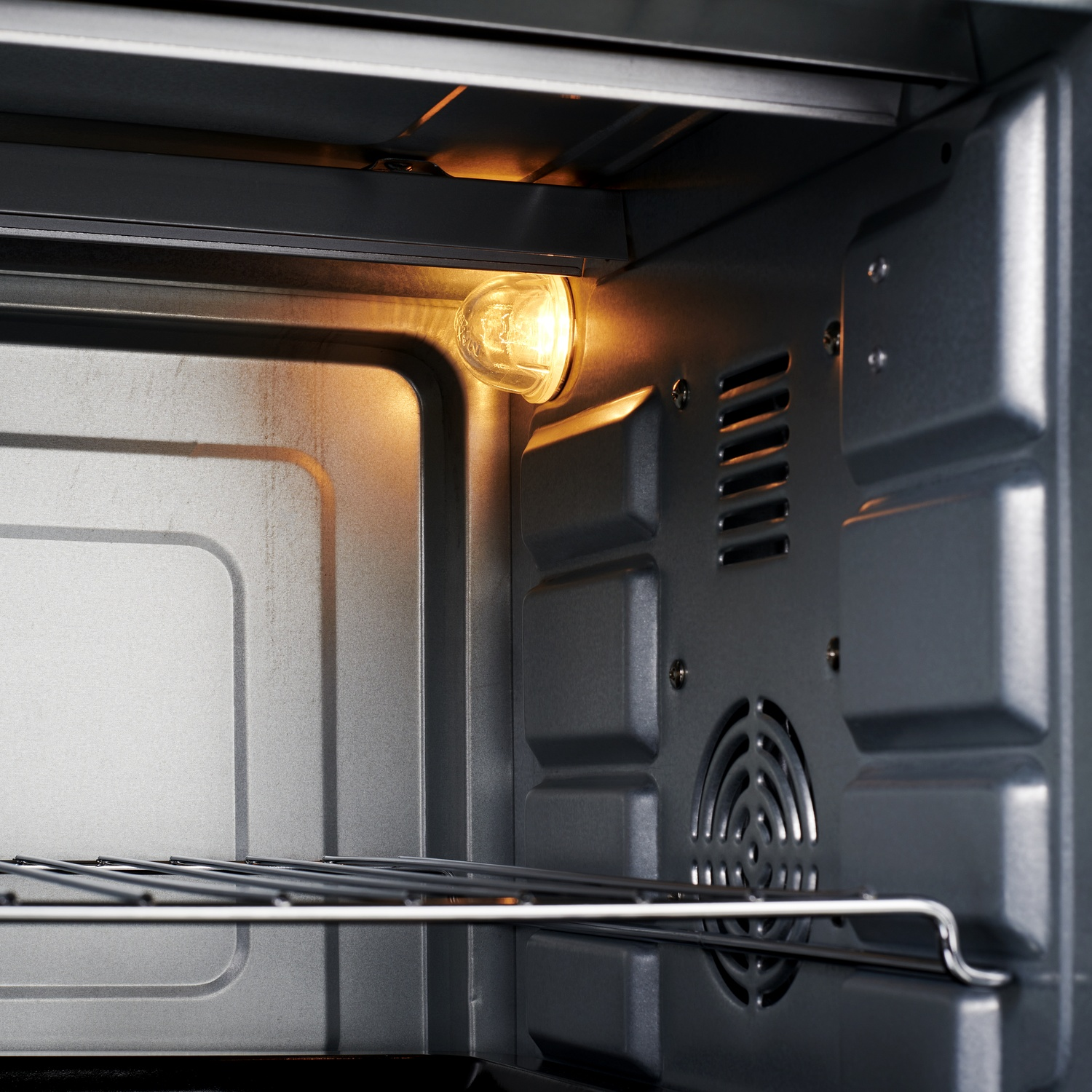 L'interno di un forno con una luce accesa e una griglia.