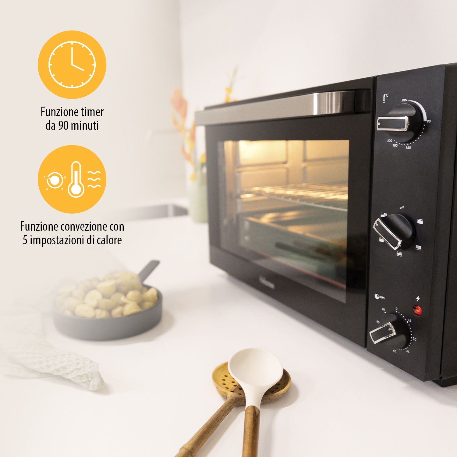 Un forno da banco nero con controlli e icone per funzioni timer e convezione.