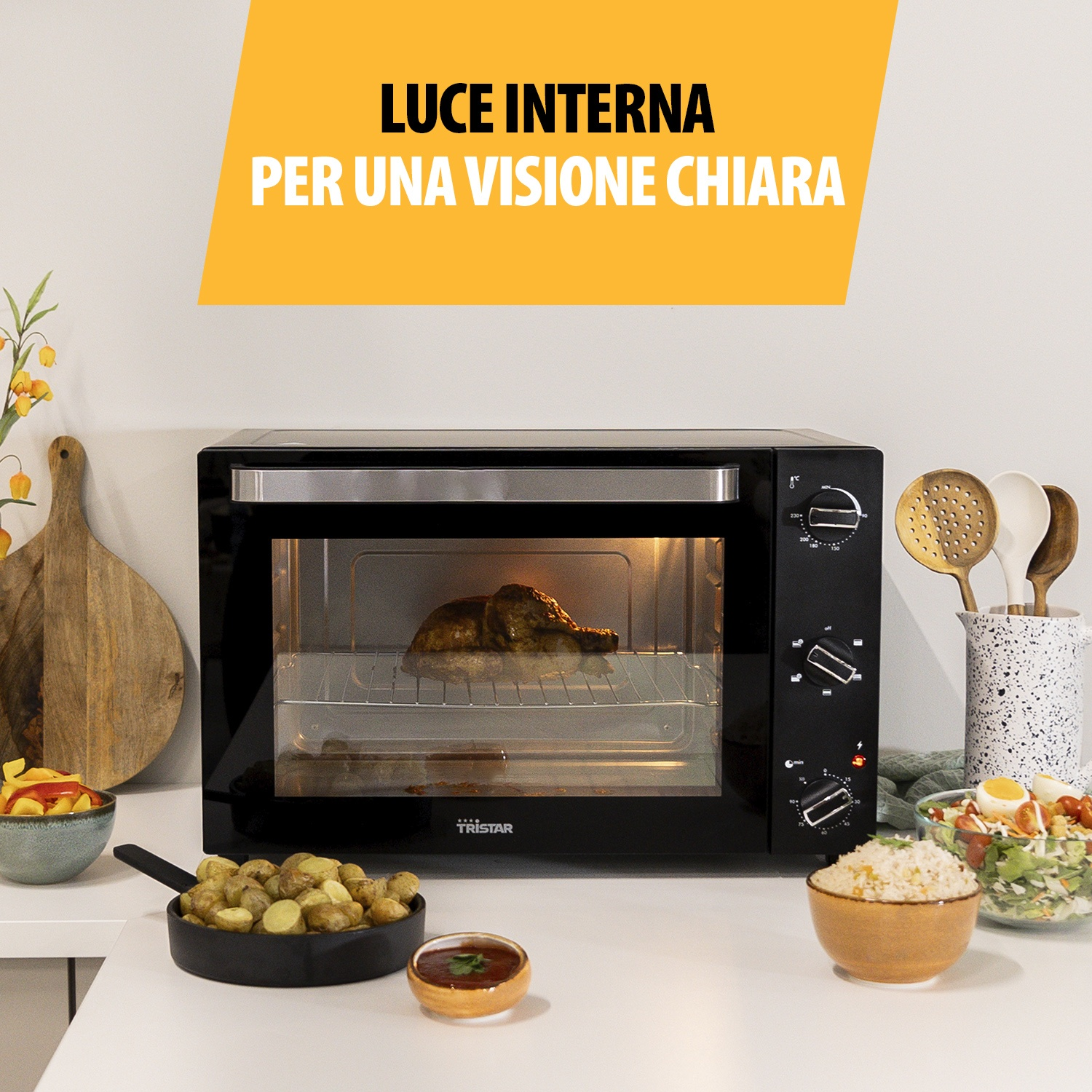Un forno da banco nero con pollo, patate, riso e insalata.