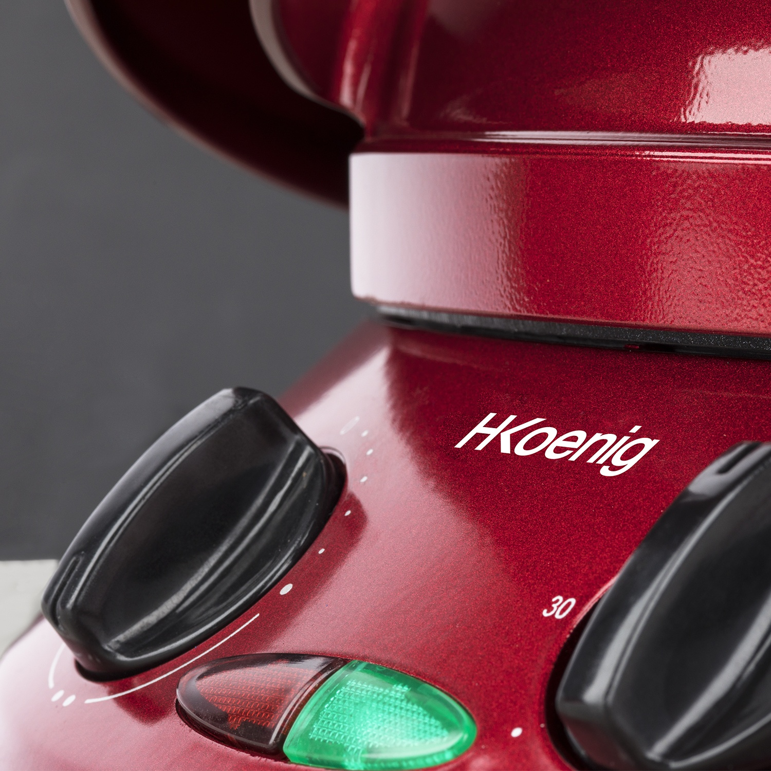 Un apparecchio rosso con manopole nere e una luce verde.