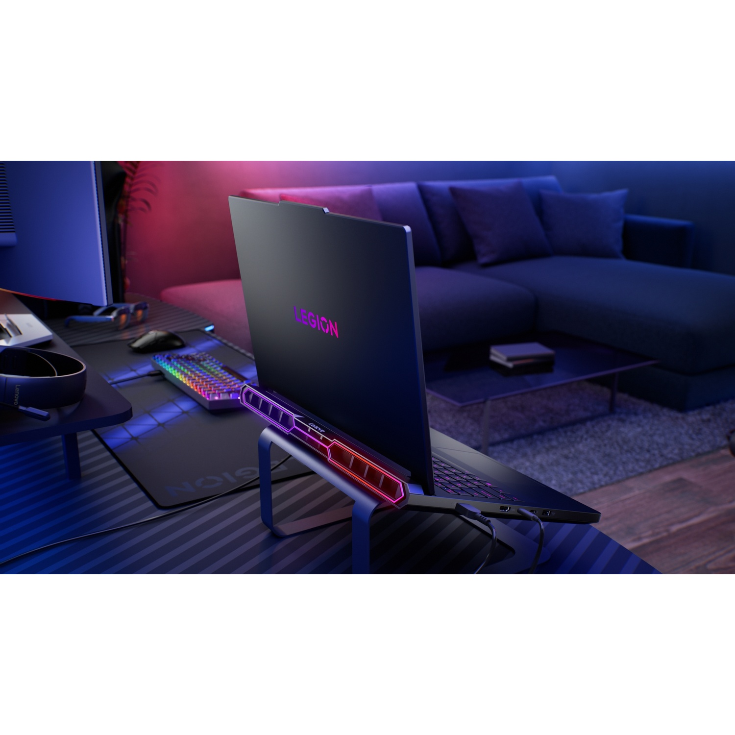 Un laptop Legion nero poggia su un supporto, con tastiera RGB e illuminazione d'ambiente.