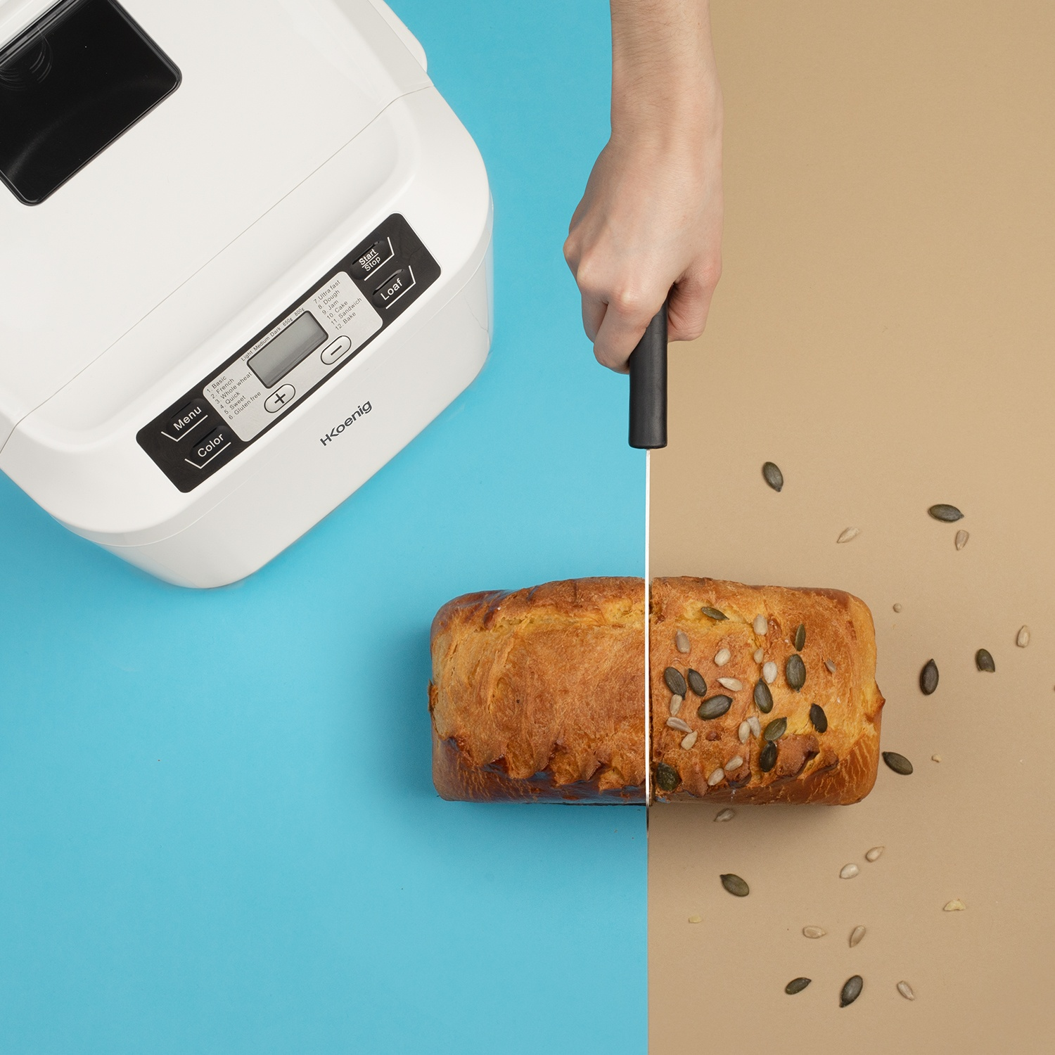 Una macchina per il pane bianca accanto a una pagnotta tagliata a metà.