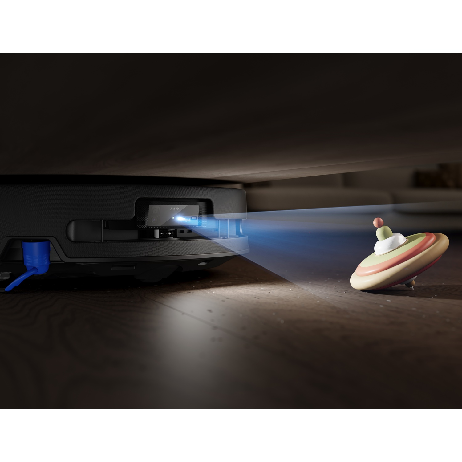 Un robot aspirapolvere scansiona un trottola sul pavimento con un raggio di luce blu.