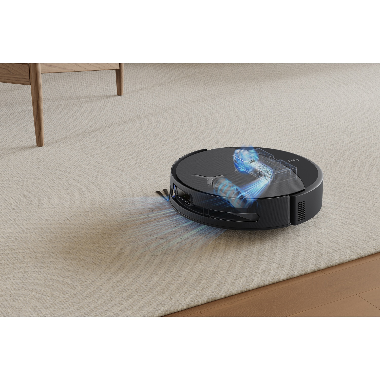 Un robot aspirapolvere nero pulisce un tappeto beige chiaro con visibile potenza di aspirazione.