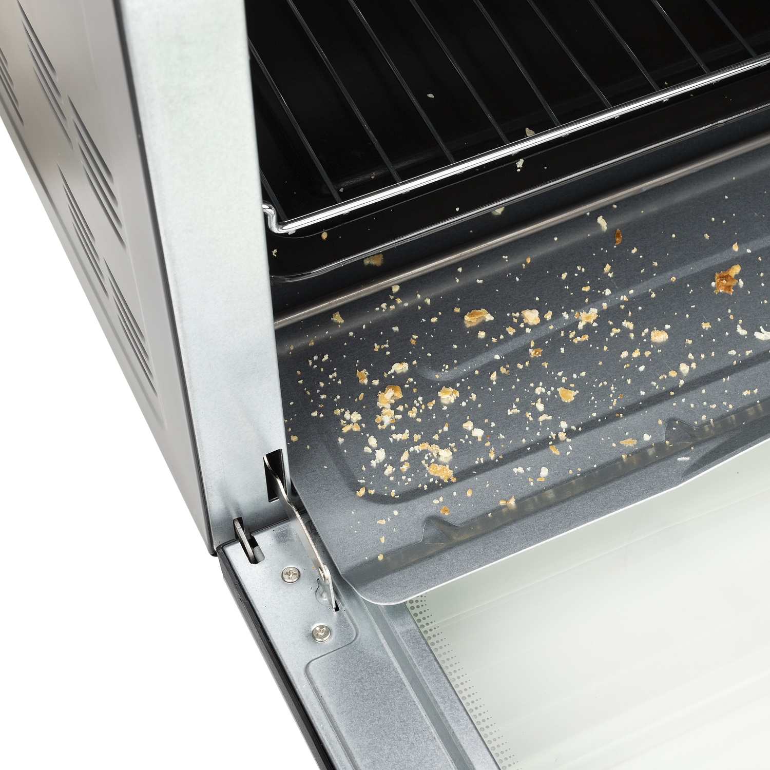 Briciole sulla leccarda di un forno metallico aperto con griglia.