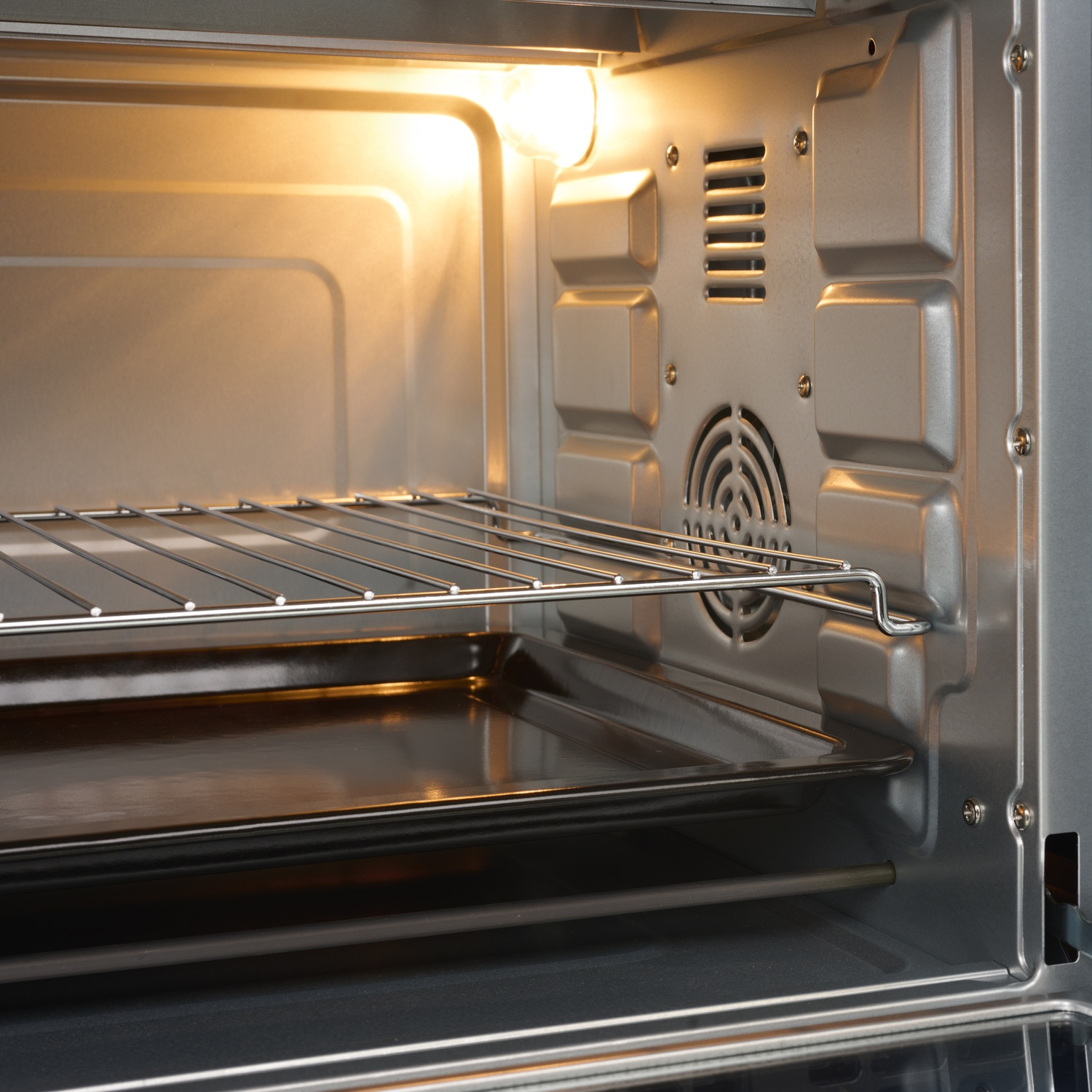 Vista interna di un forno vuoto con una griglia e una teglia.