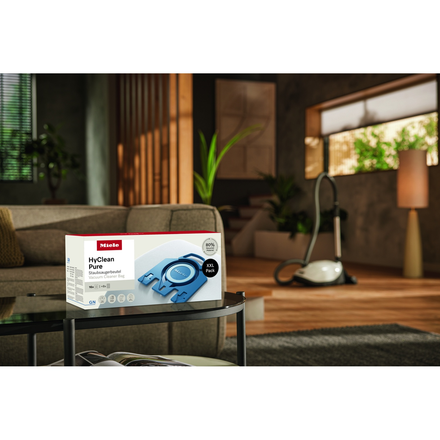 Sacchetti aspirapolvere Miele HyClean Pure su tavolino, aspirapolvere sullo sfondo.