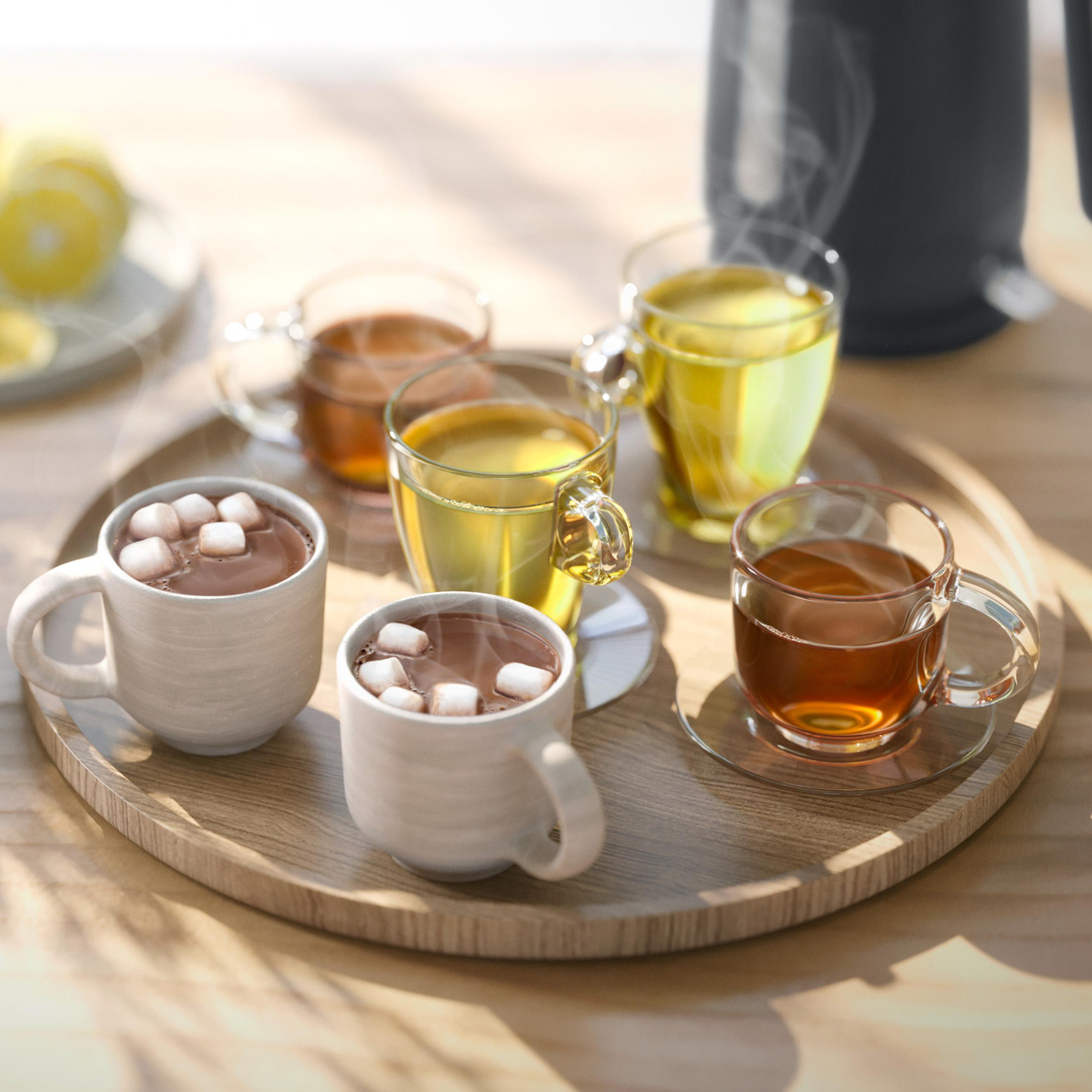 Holztablett mit Tassen: Kakao mit Marshmallows, Tee und Zitrone.