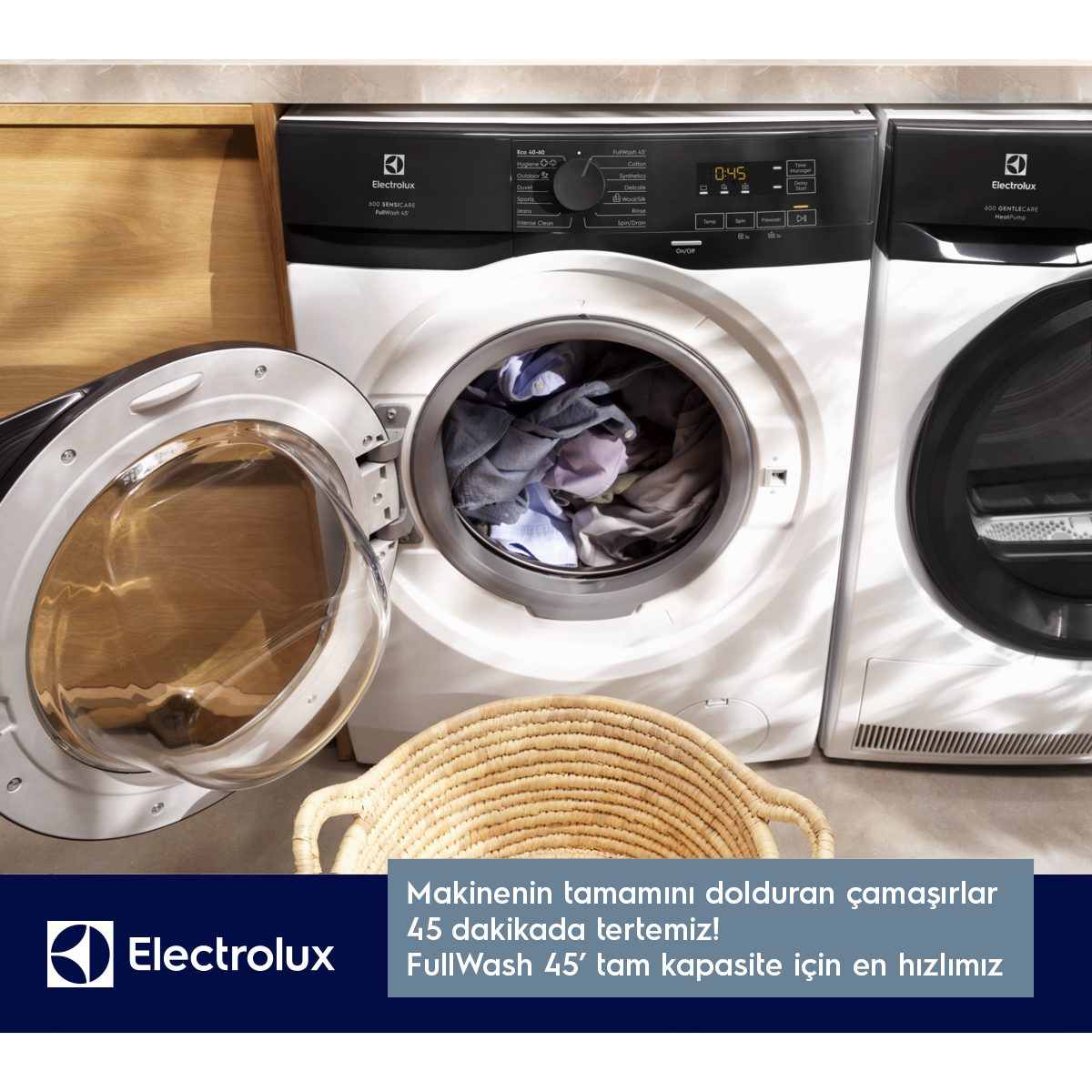 Electrolux çamaşır makinesi çamaşır dolu, önünde sepet var.